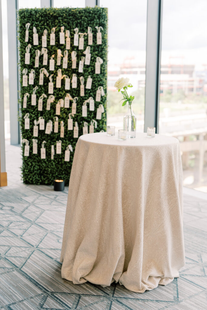 Linen cocktail table with escort card display in background.