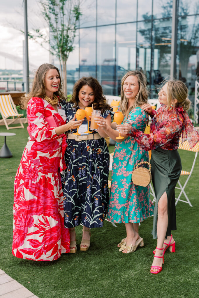 Four women toasting and laughing. 