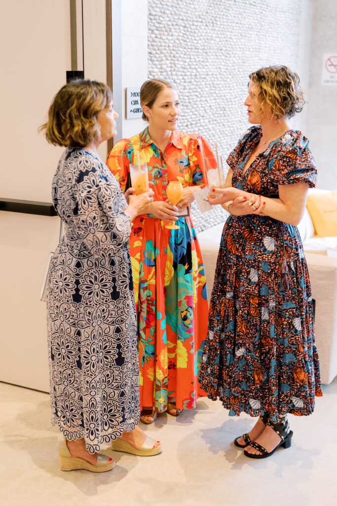Three women talking at during cocktail hour.