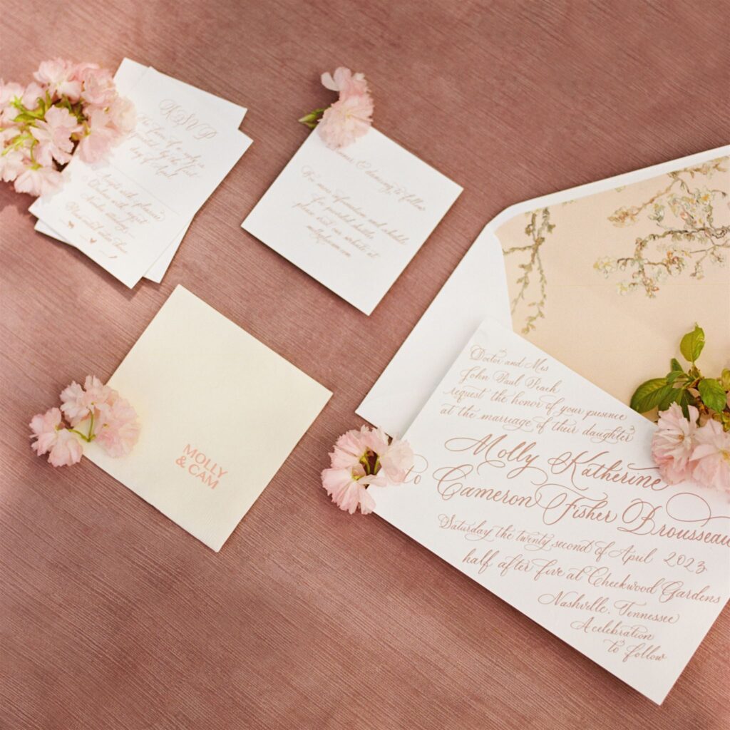 Invitation suite flat lay boasting full spot calligraphy and florals.