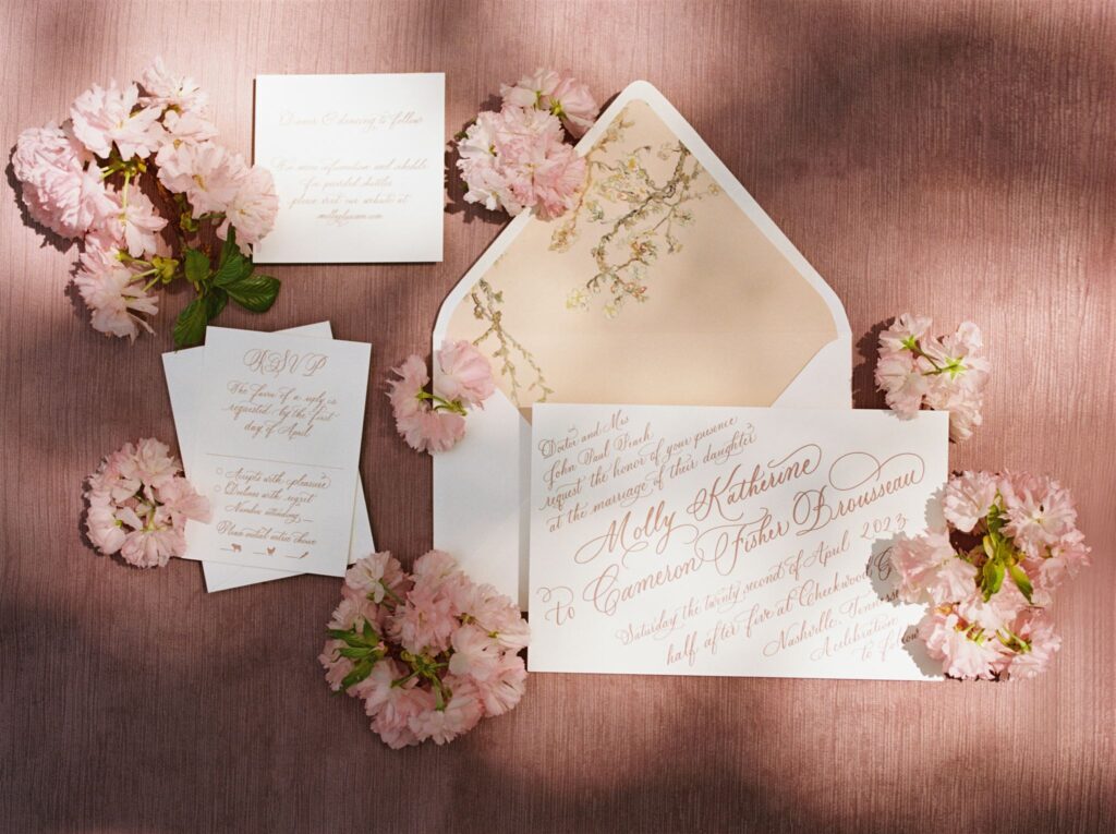 Invitation suite flat lay boasting full spot calligraphy and florals. 