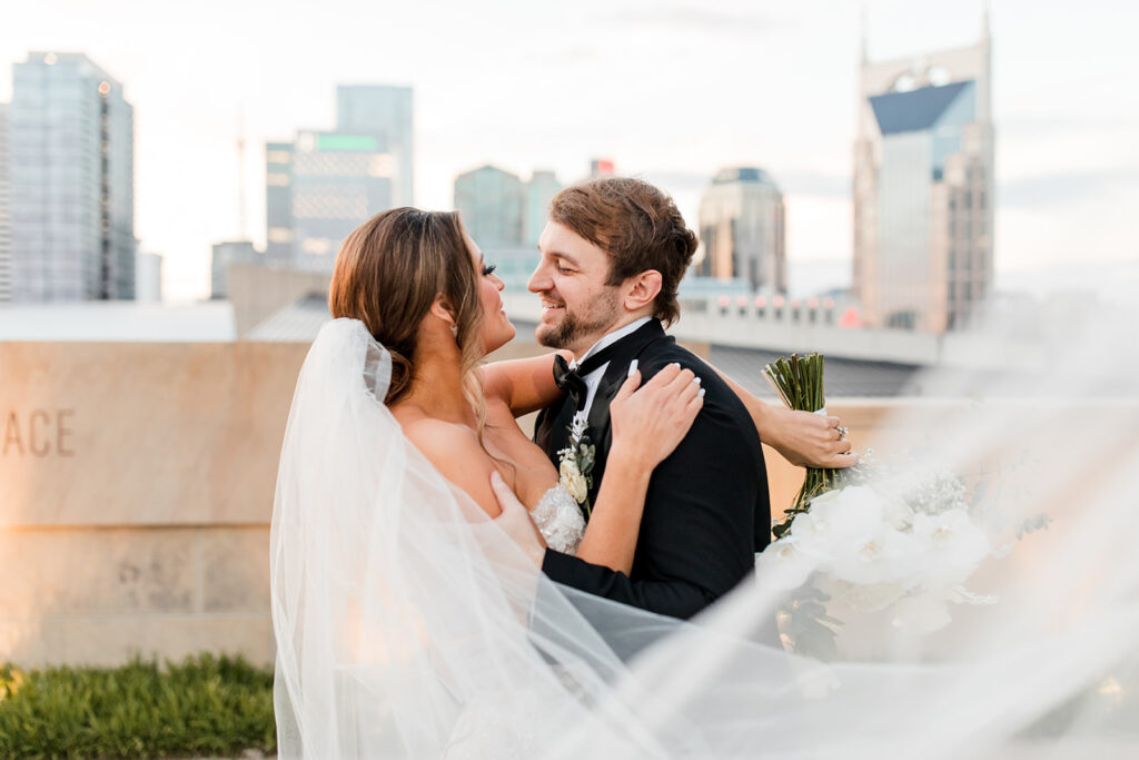Bride and Groom embracing in front of city skyline.