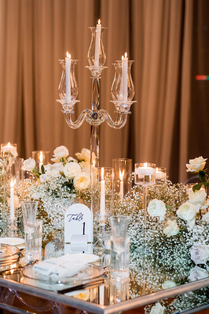 Formal tablescape of dinner setting, florals, lighting, table numbers and menus.