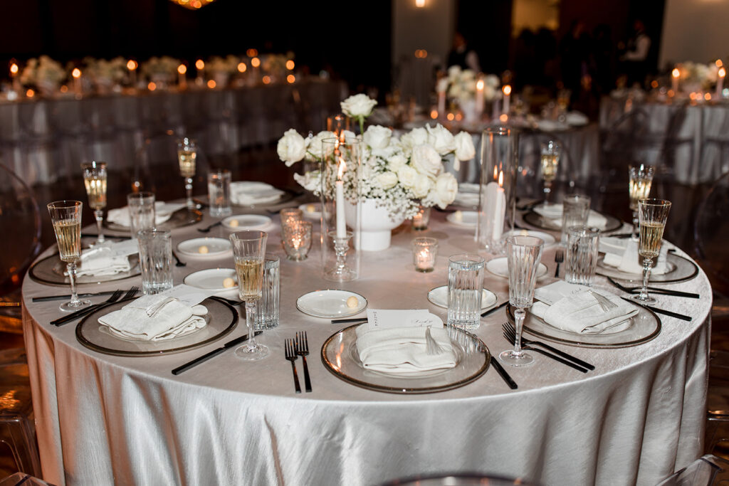 Formal table setting with custom menu tucked into napkin on plate.