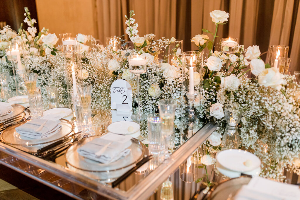 Formal tablescape of dinner setting, florals, lighting, table numbers and menus.