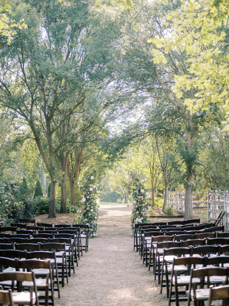 Outdoor wedding seating area under tree canopy.