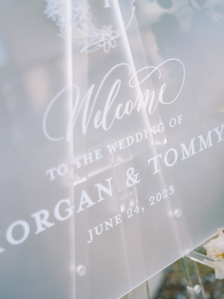 Outdoor frosted acrylic wedding welcome sign on easel.