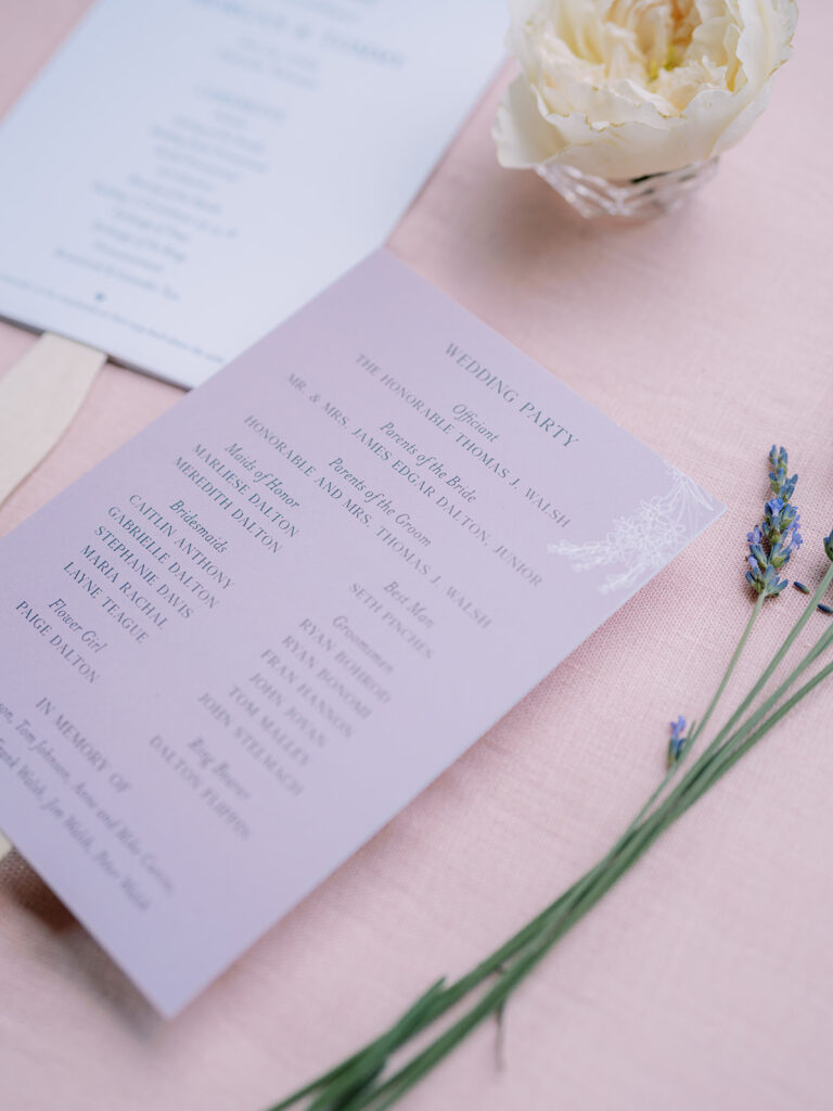 Ceremony programs with wooden handles styled with flower and lavender.
