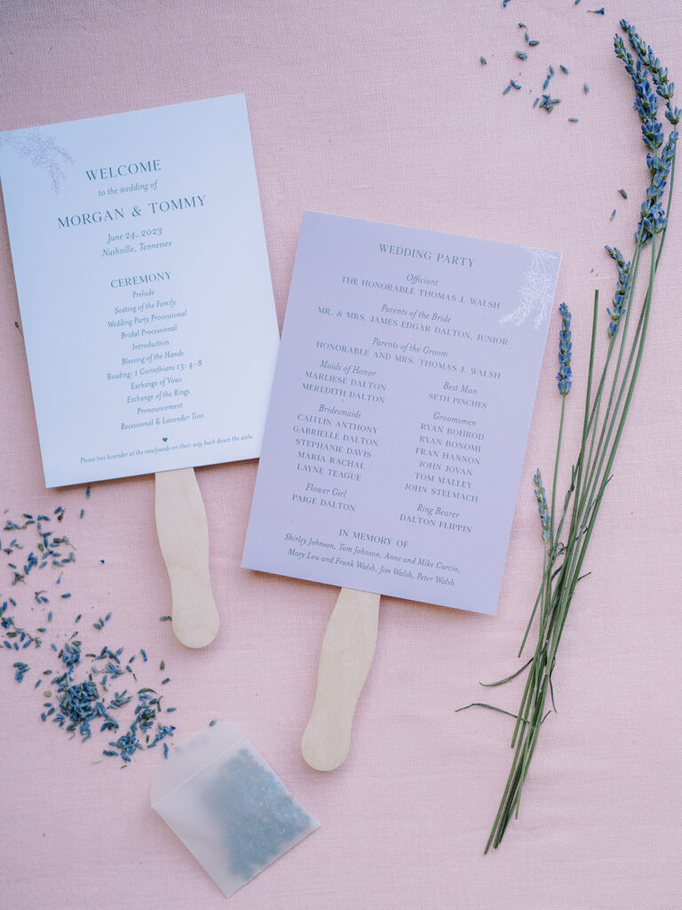 Ceremony programs with wooden handles styled with flower and lavender and lavender seeds.