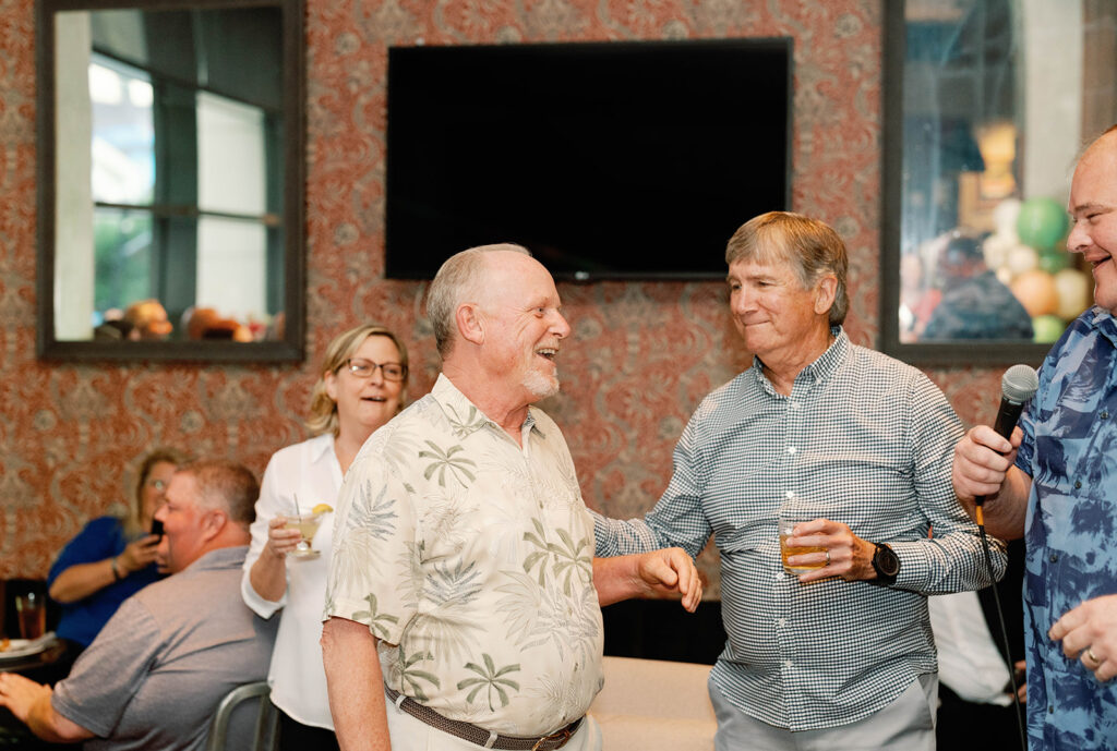 Two men laughing together at cocktail hour