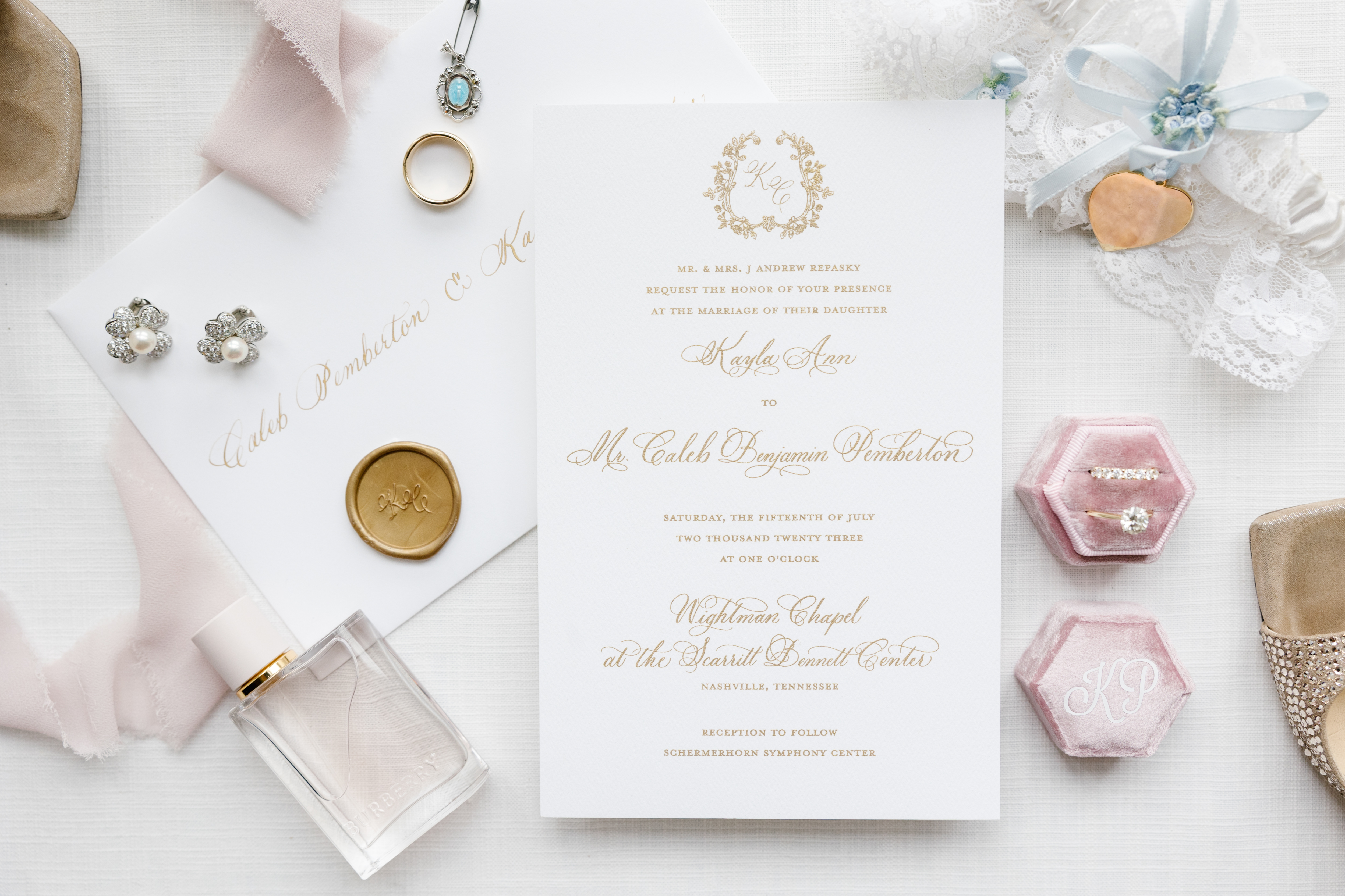 Wedding invitation suite styled along with jewelry, perfume, garter and other fabrics.