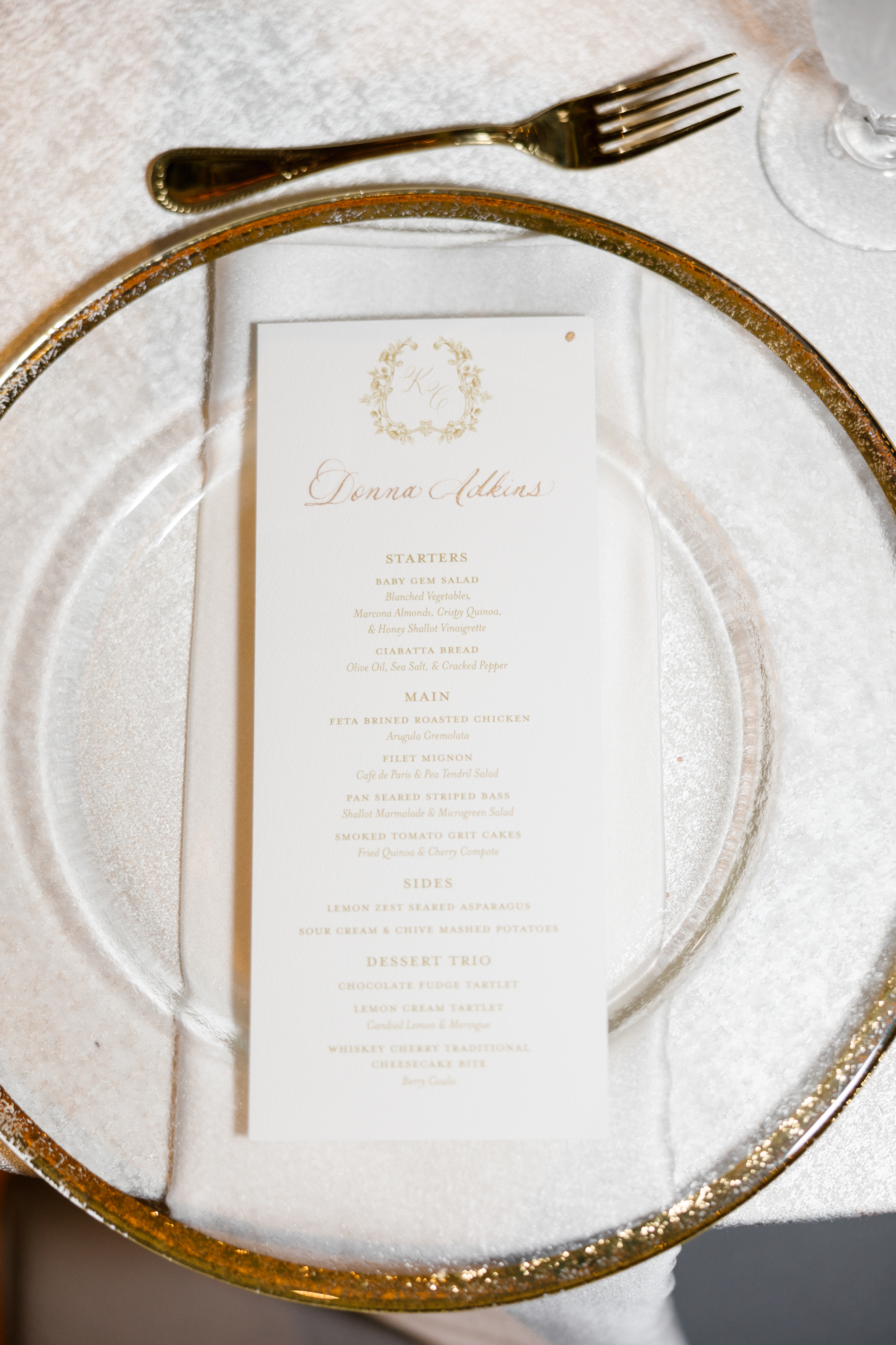 Custom dinner menu on top of gold rim plate.