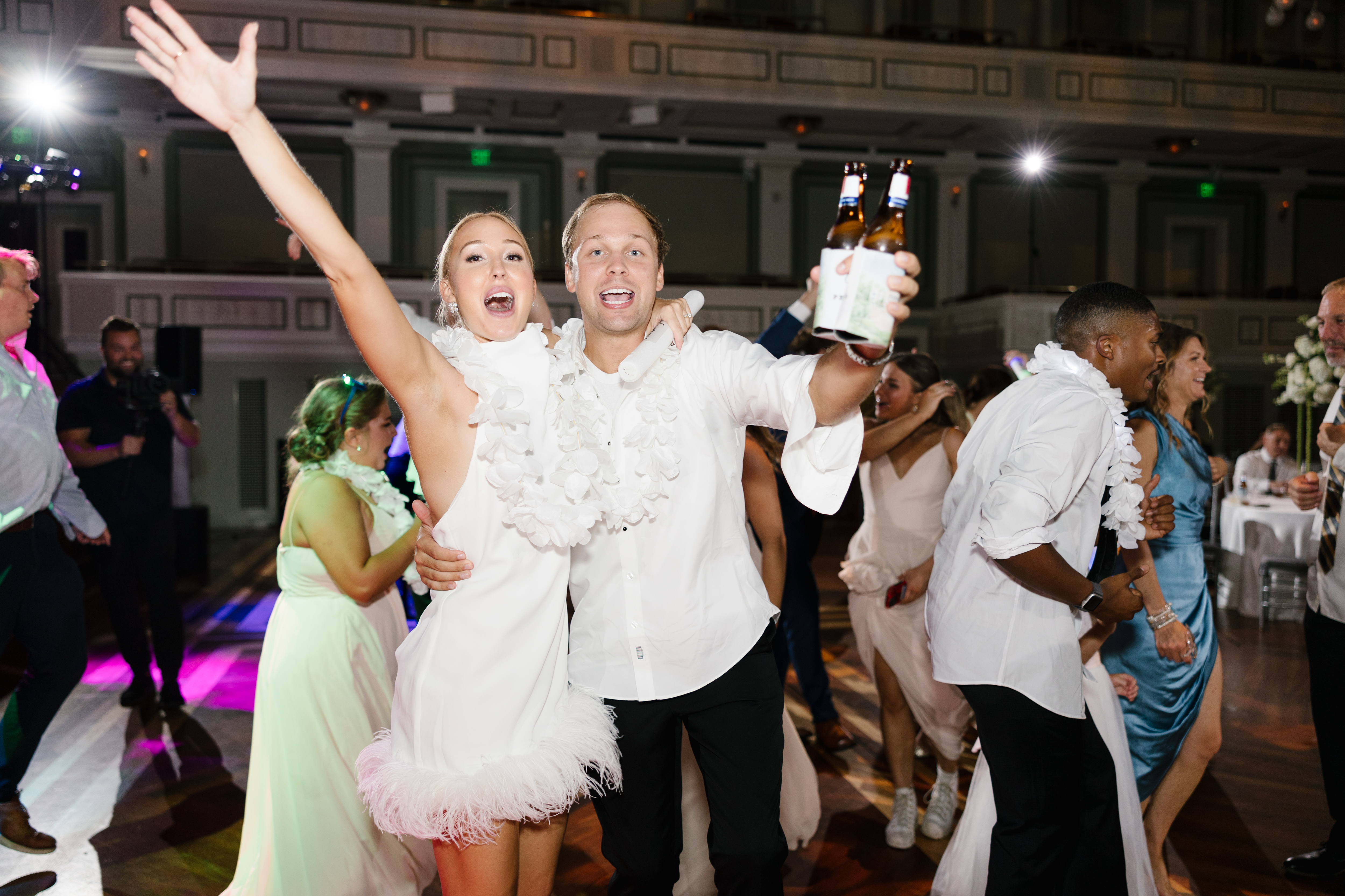 Bride cheering with guest on the dance floor. 