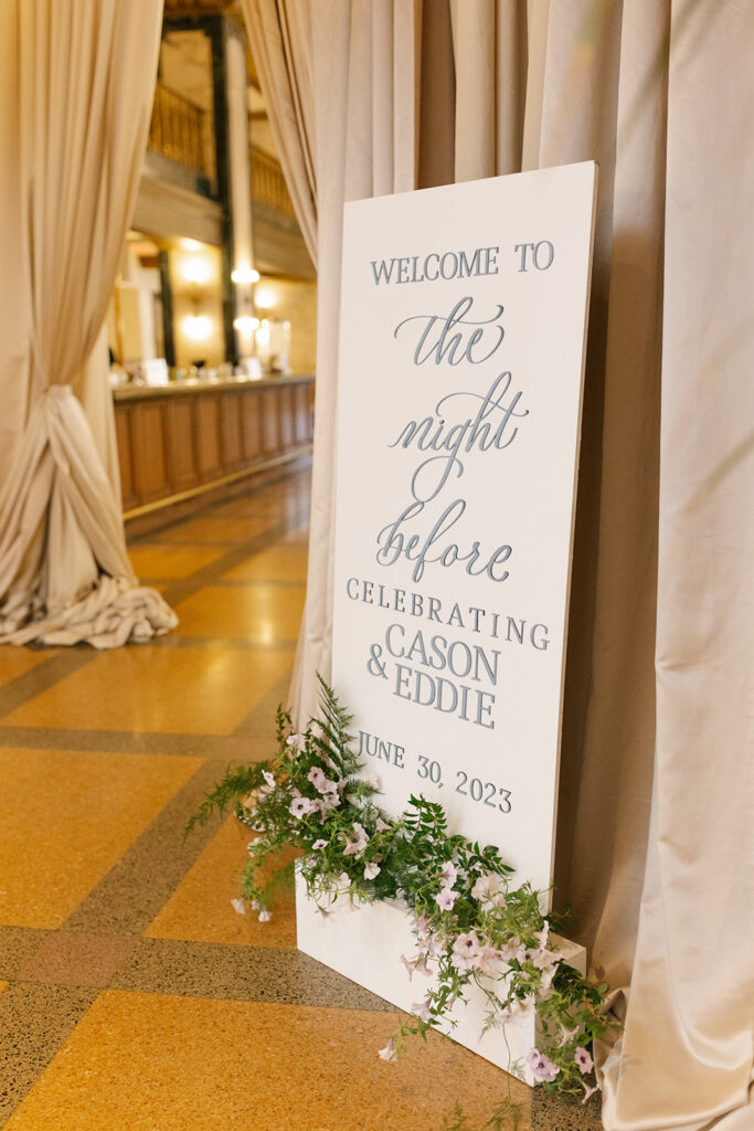 Custom Welcome Sign in front of draped entrance and ornamented with florals