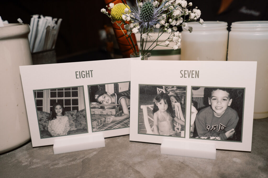 table number signs with photos of bride and groom at matching ages.