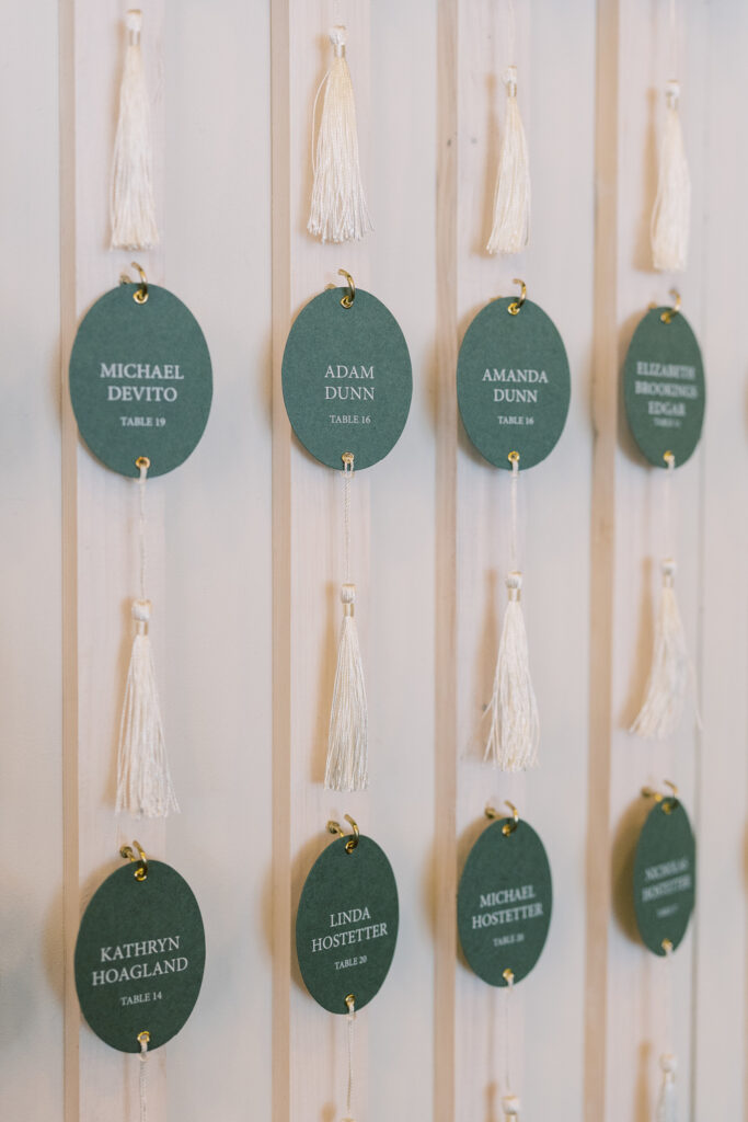 Hanging, oval, escort cards with tassels.