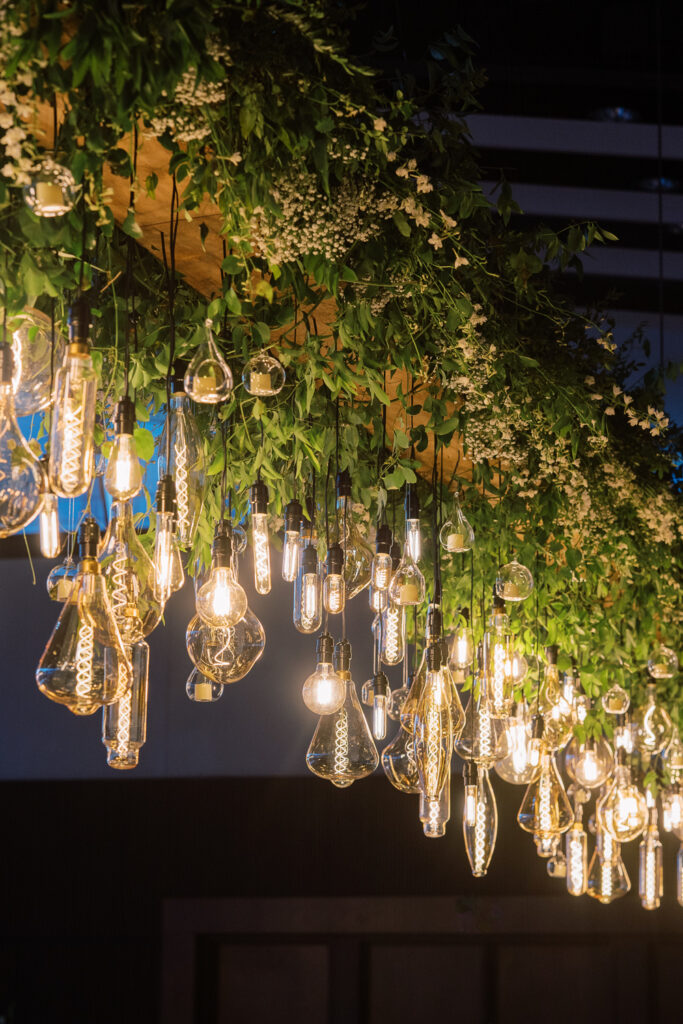 Hanging floral chandelier styled with vintage lighting.