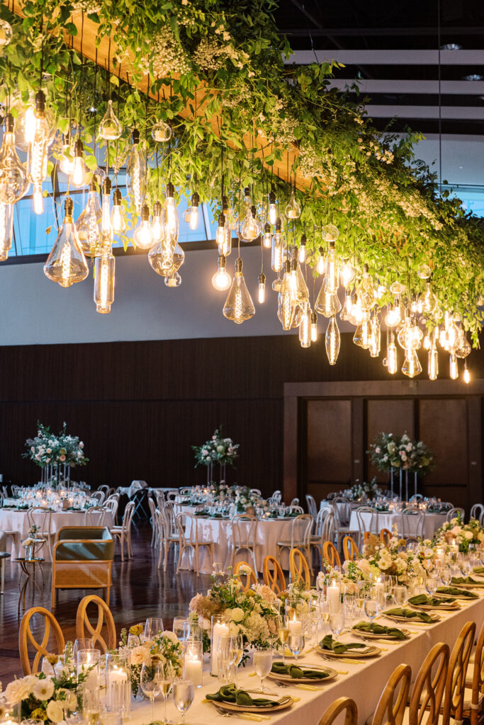 Formal wedding reception venue set up with formal table set ups and hanging floral chandelier.