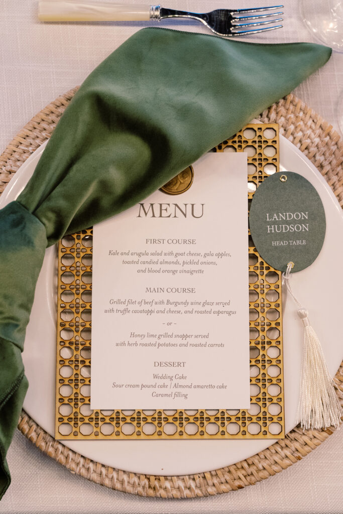 Custom reception menu and escort card displayed on formal dining table set.