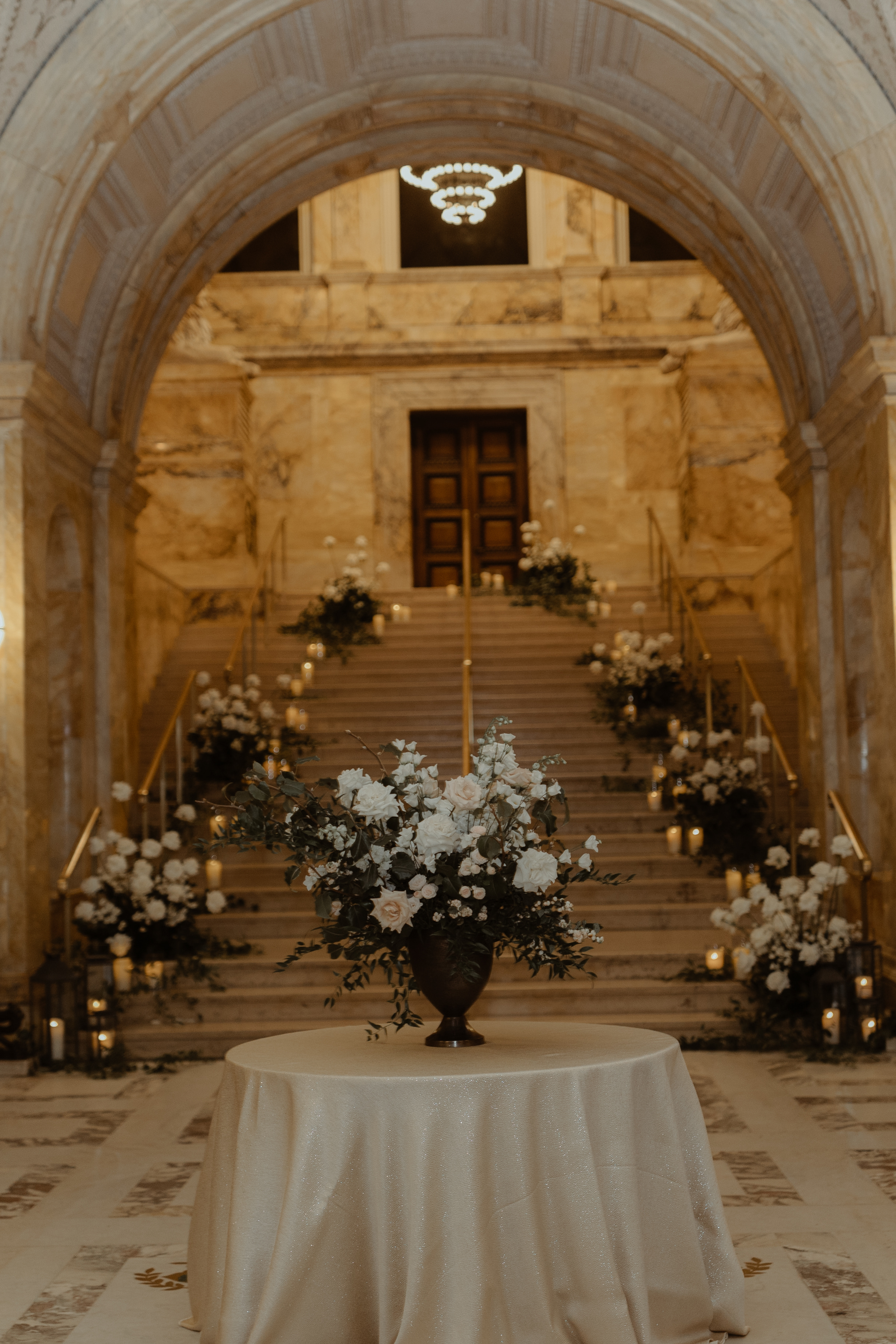formal table of floral arrangement at entrance of staircase styled in florals