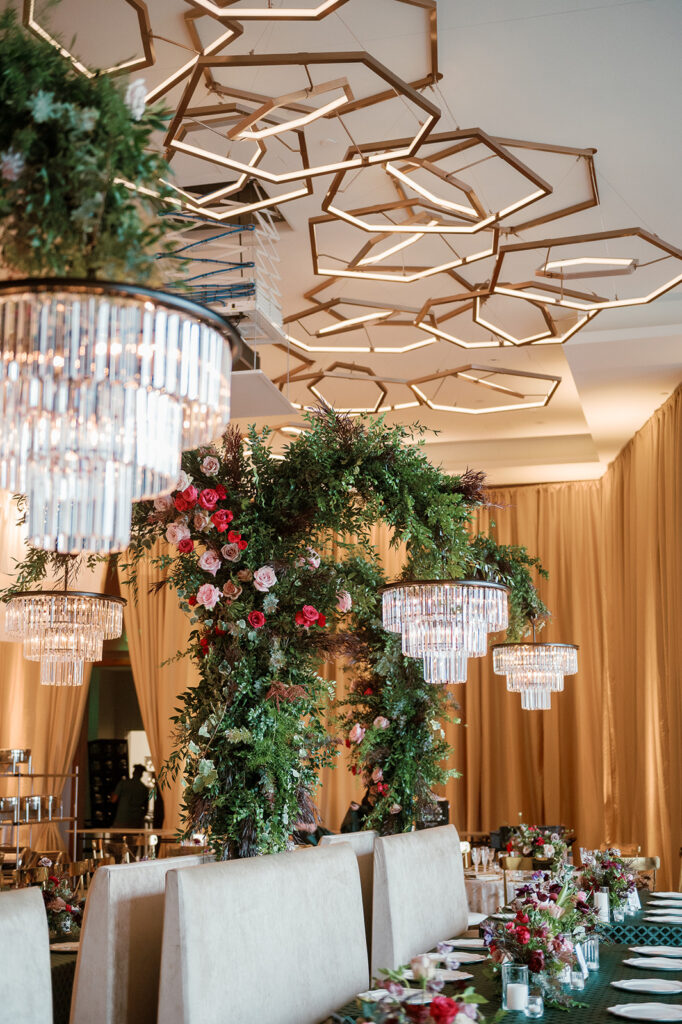 Formal reception dining area styled with linen tables, chandeliers, and floral arrangements.