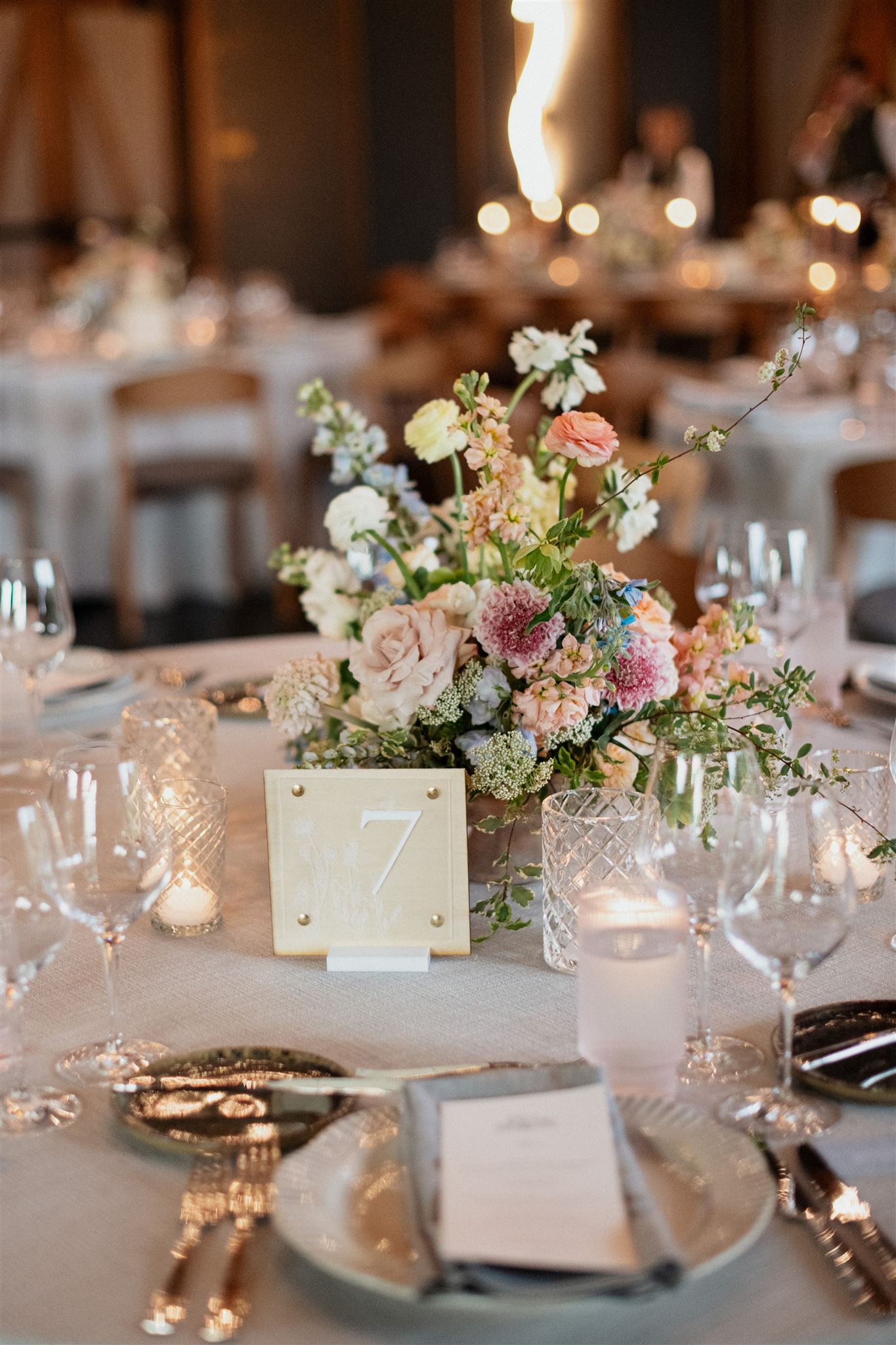 Custom Spring Wedding Details at Formal reception. Dining place setting with table menus, candles and floral arrangements.