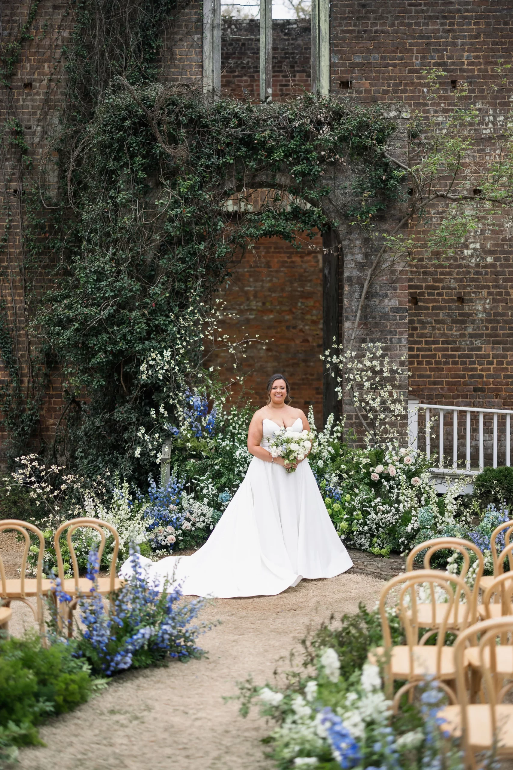 bride holding white bouquet surrounded by enchanting florals from Romantic Barnsley Resort Wedding