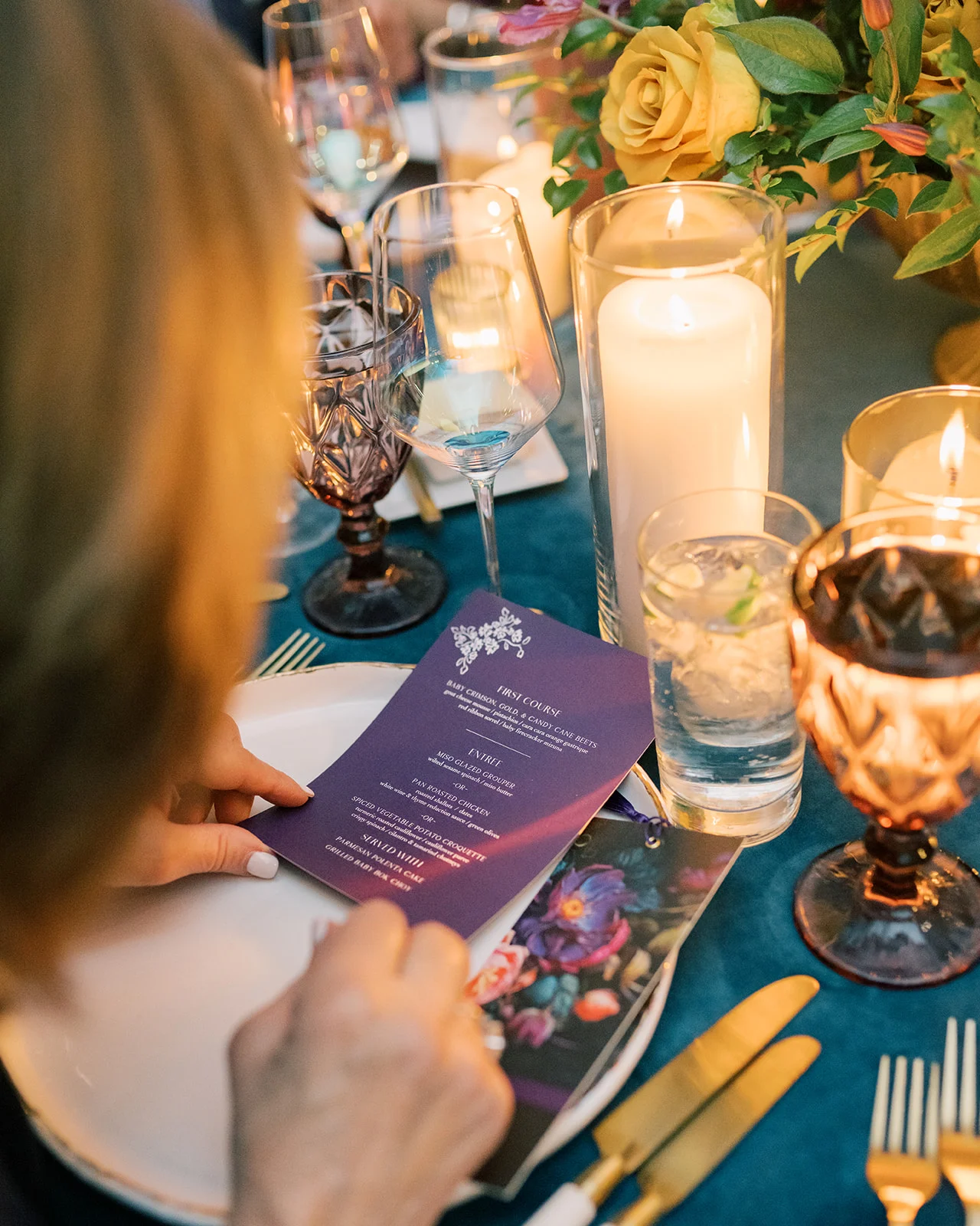 woman looks down at menu on plum paper