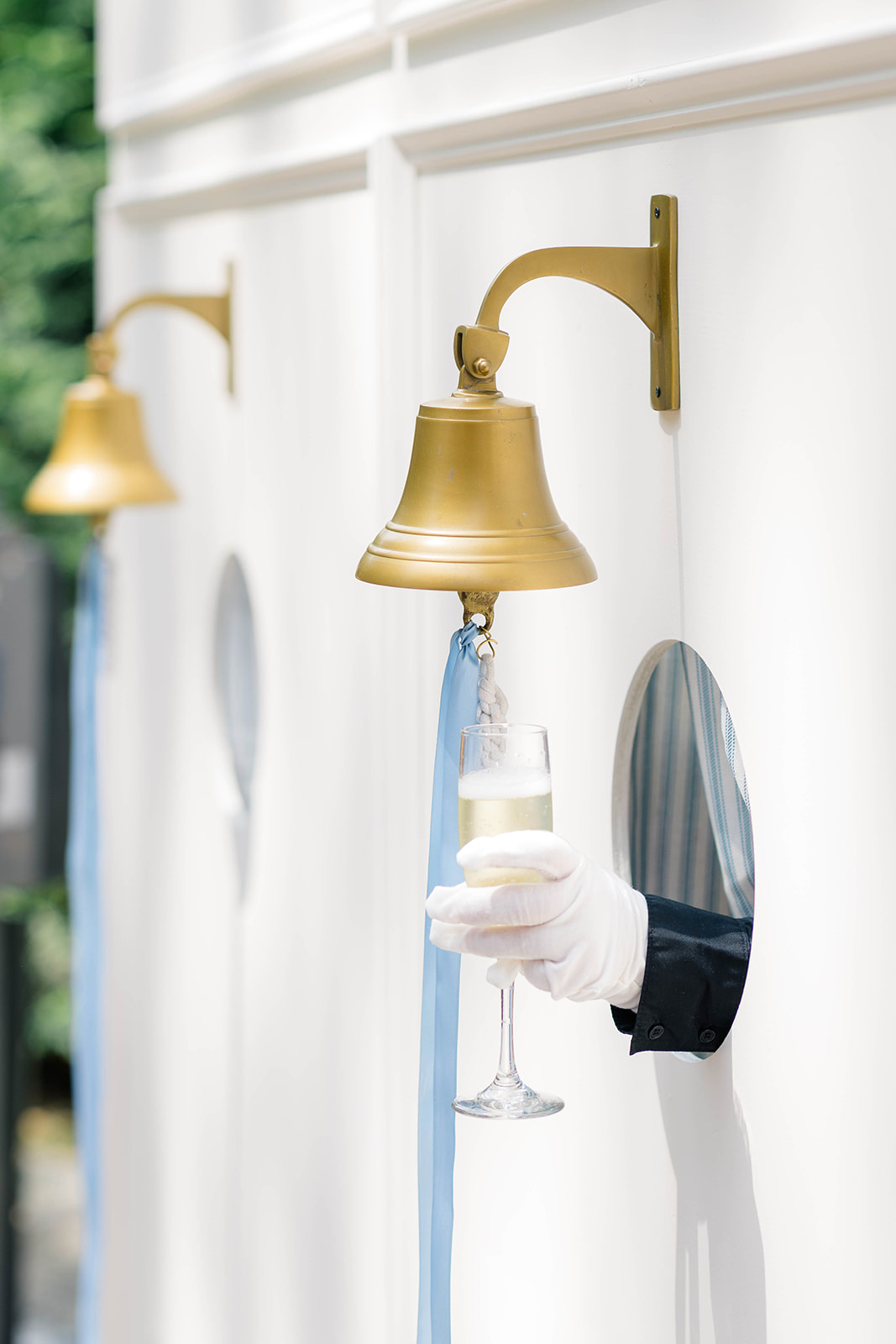hand passes out champagne through a hole on wall
