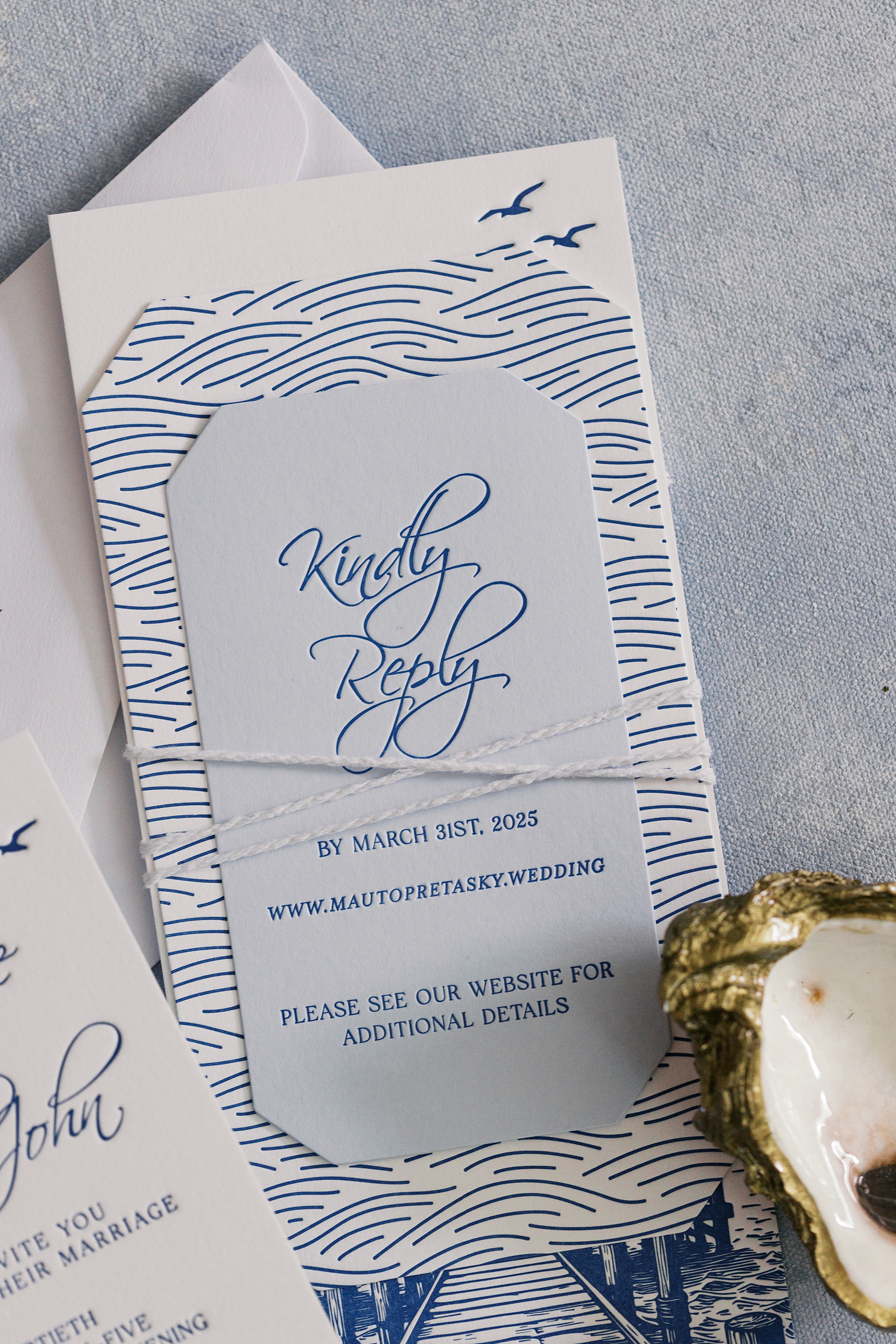 invitation stack displays beautiful artwork on invitation suite tied with white twine