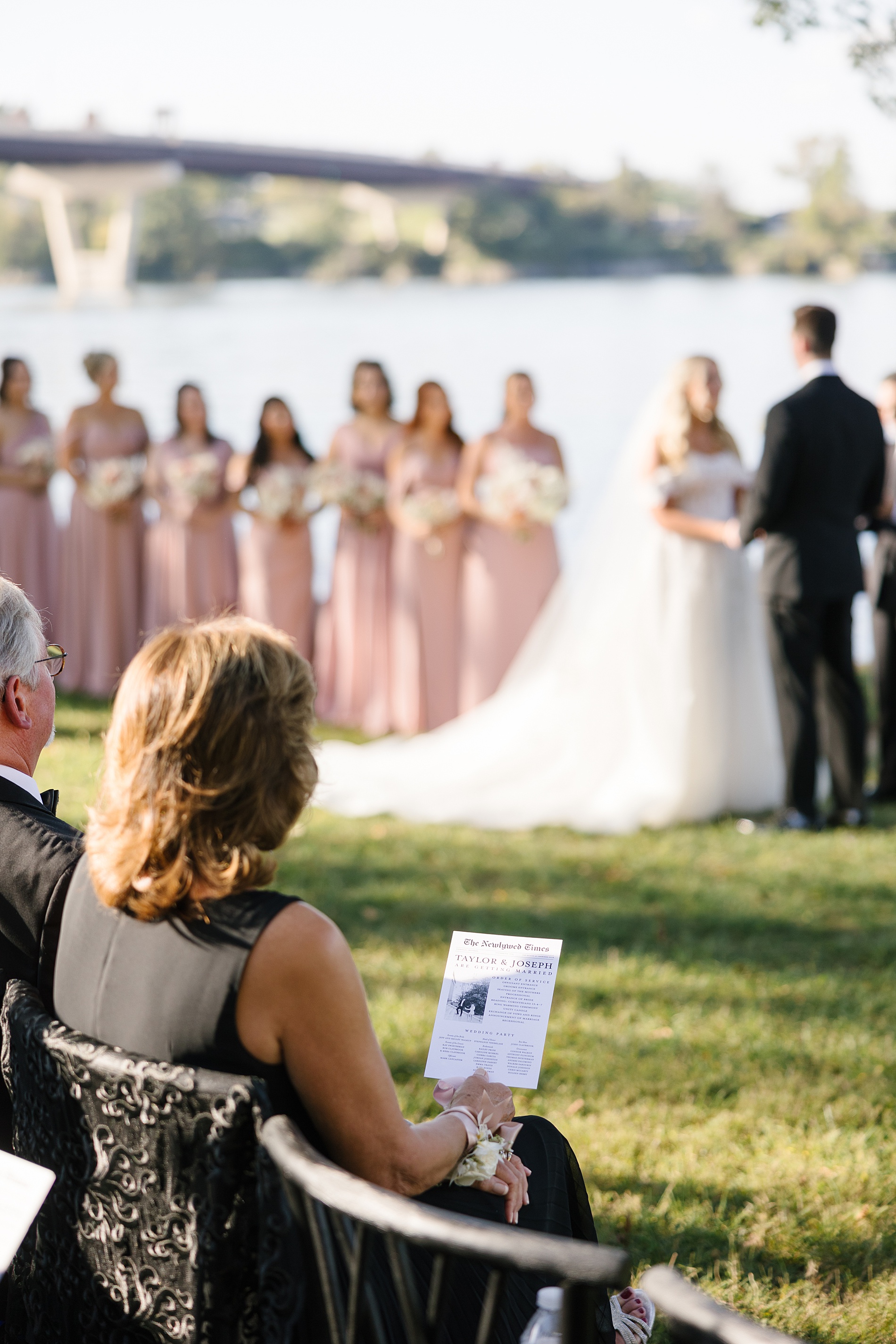 guests at wedding ceremony holding newspaper styled fan that doubled as a program and wedding timeline