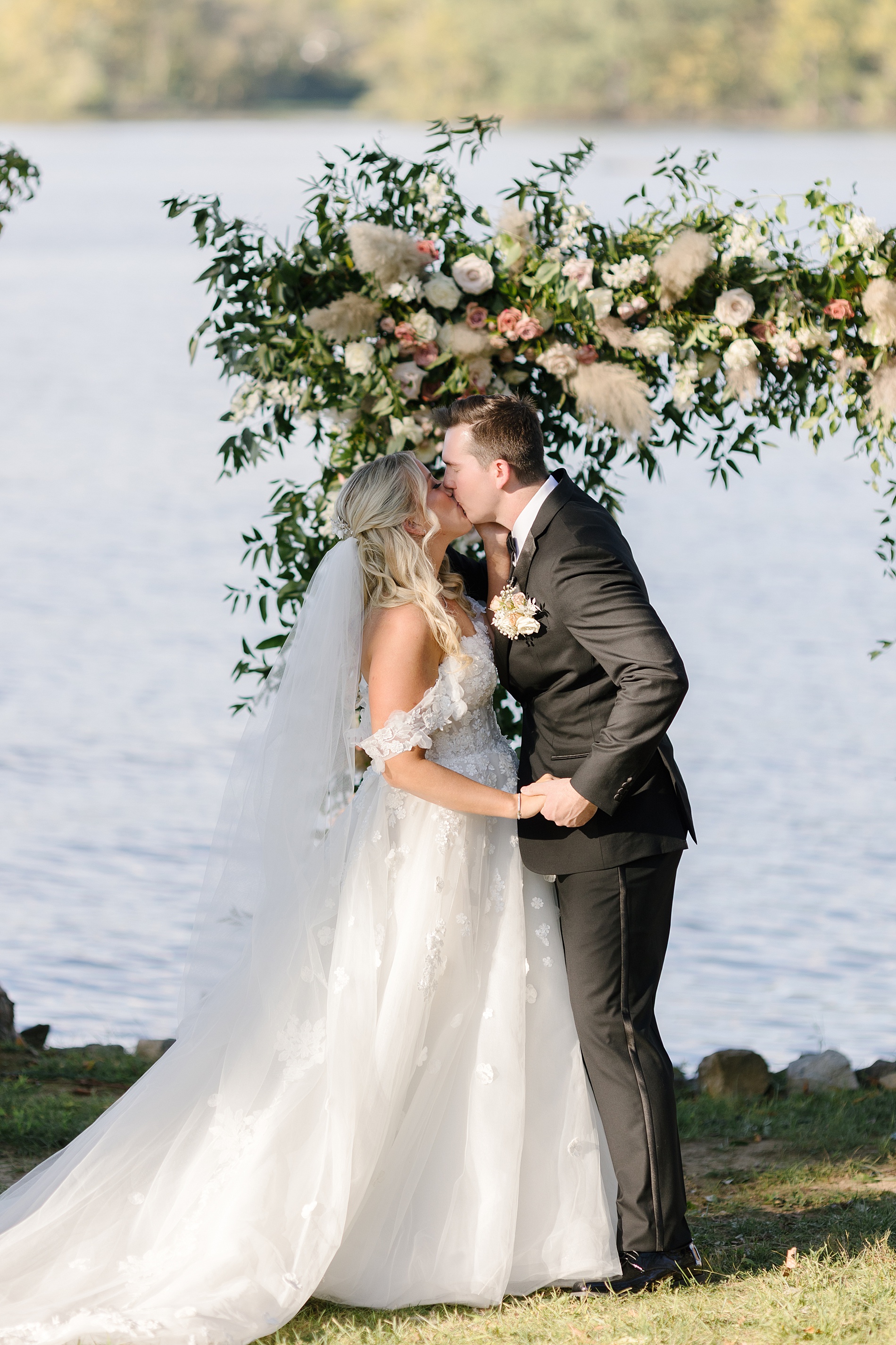 newlyweds kiss during outdoor fall wedding ceremony