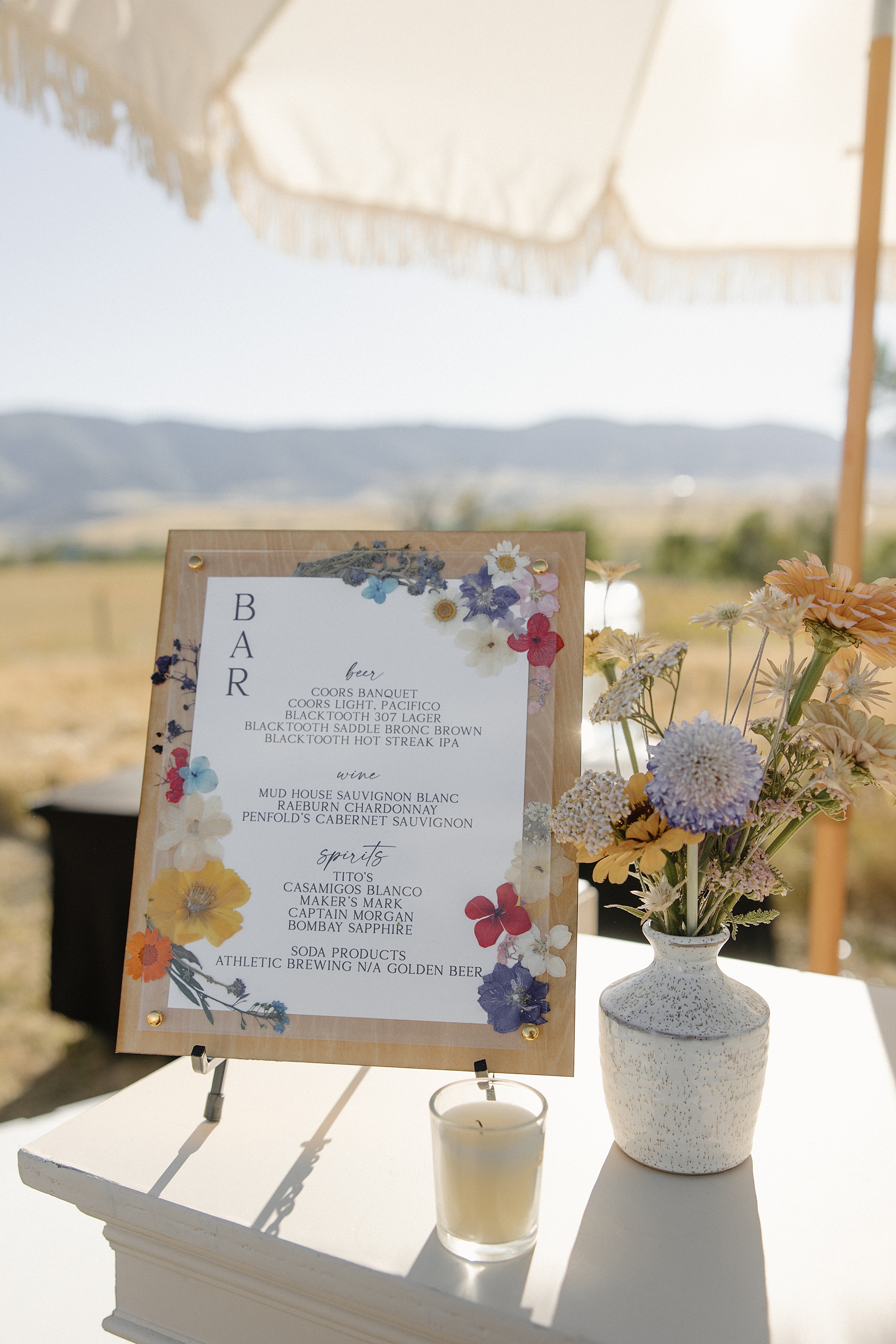 bar sign with pressed flowers from Wyoming Ranch Wedding in Sheridan, WY