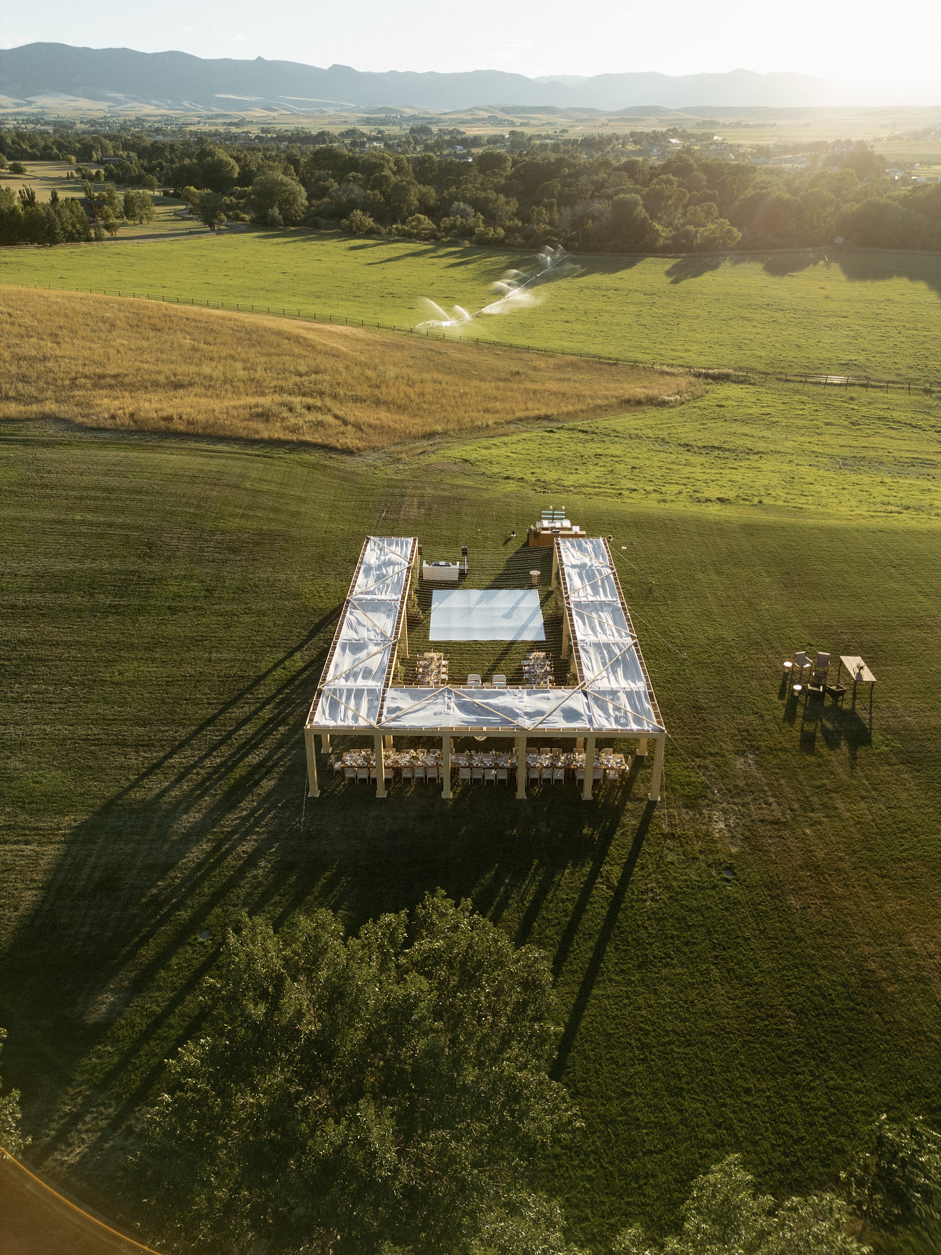 outdoor wedding reception on family ranch with tables set up in u shape 