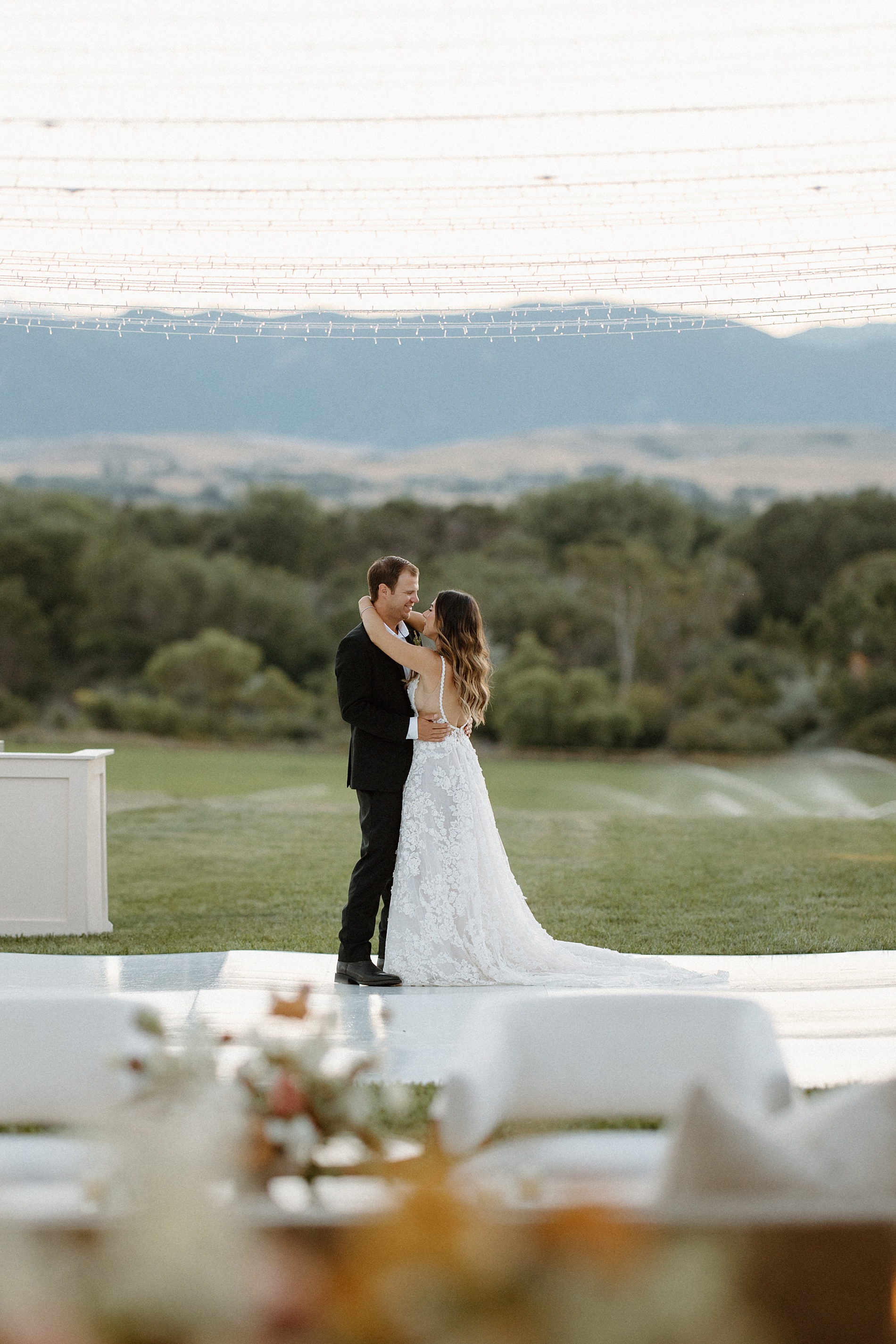 couple dance in the distance with mountains in the background 