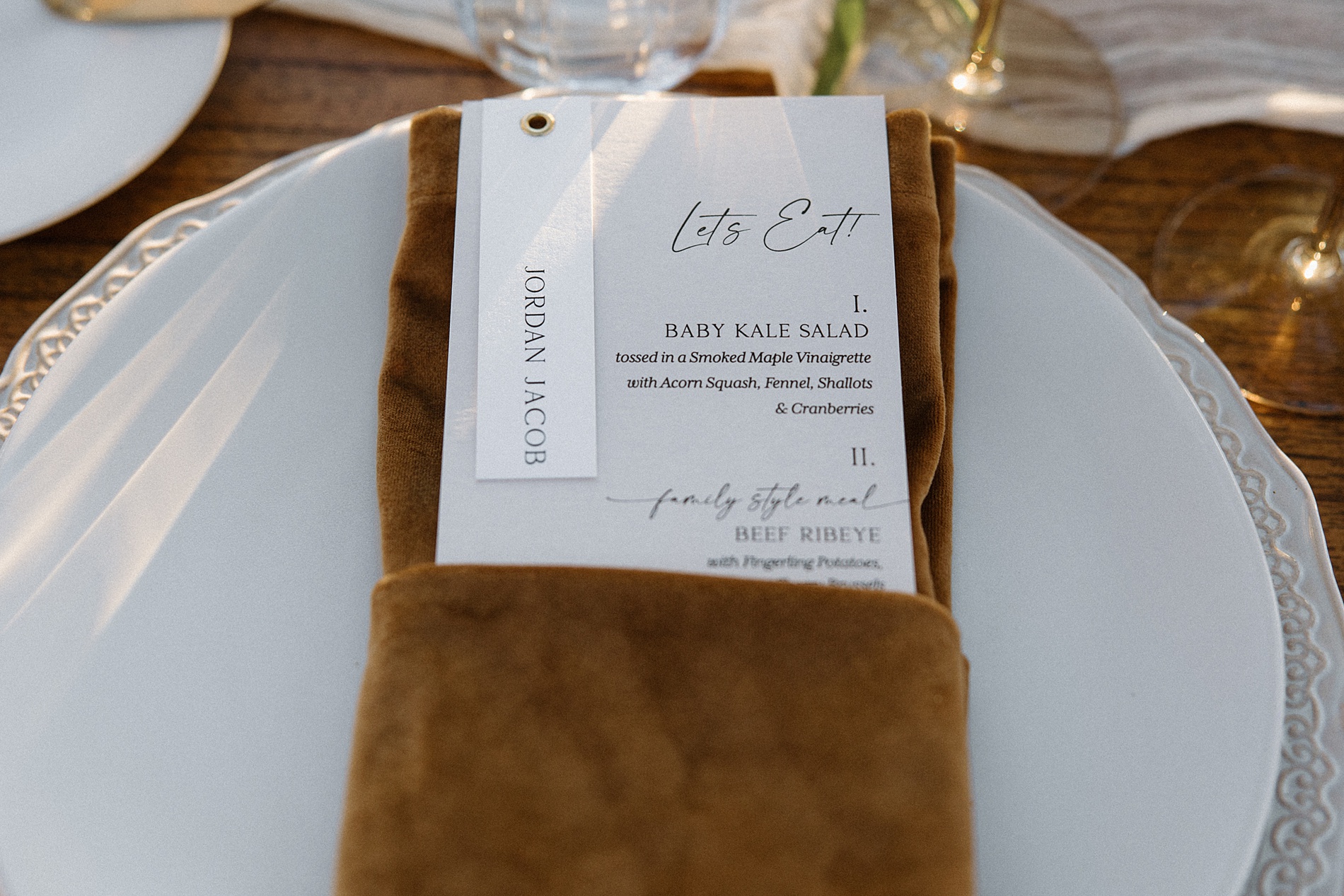 white menus with custom calligraphy and place card attached with grommet inside leather pocket 