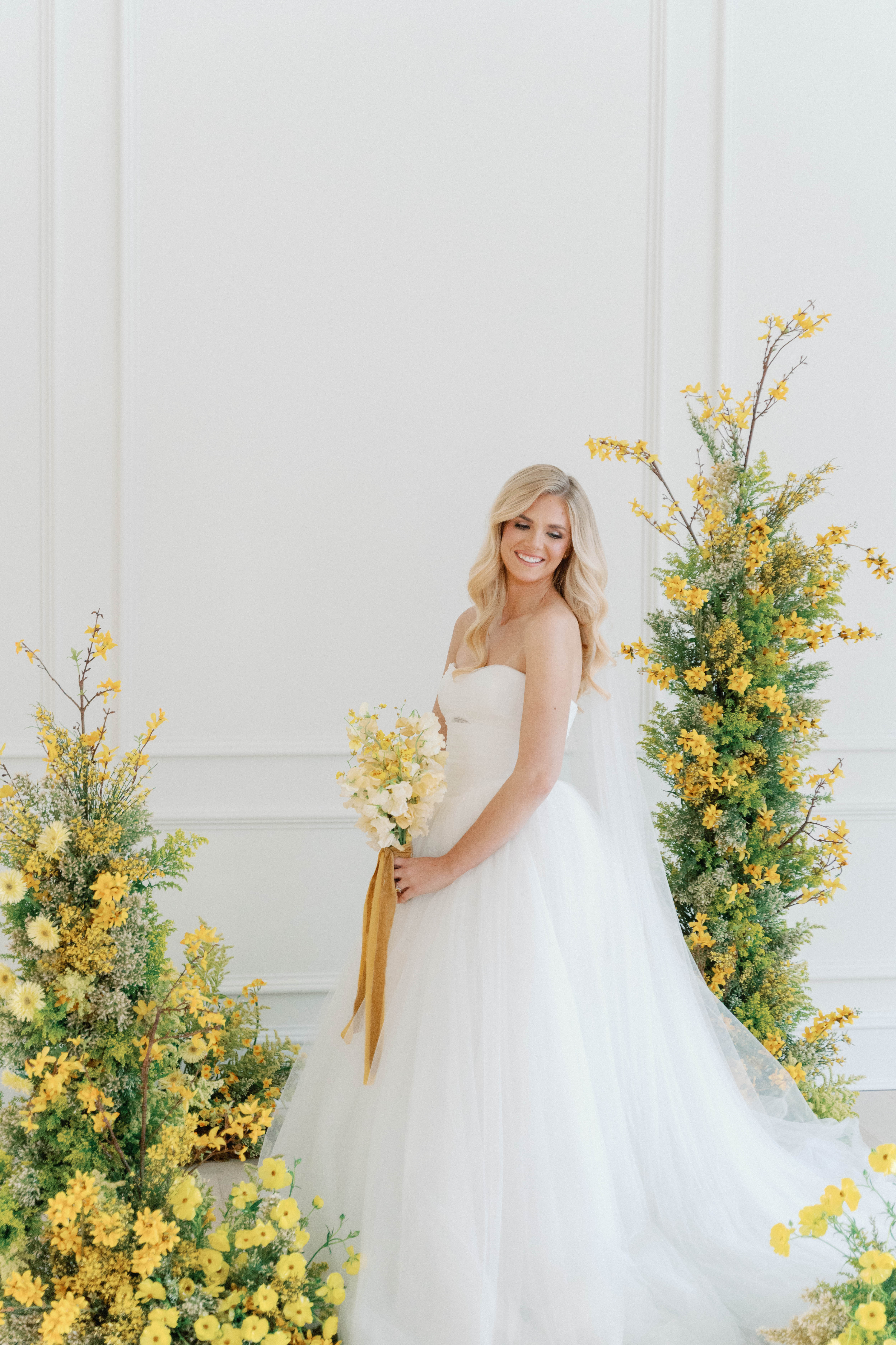stunning bride stands surrounded by yellow floral display at The Sloane Wedding shoot in Nashville
