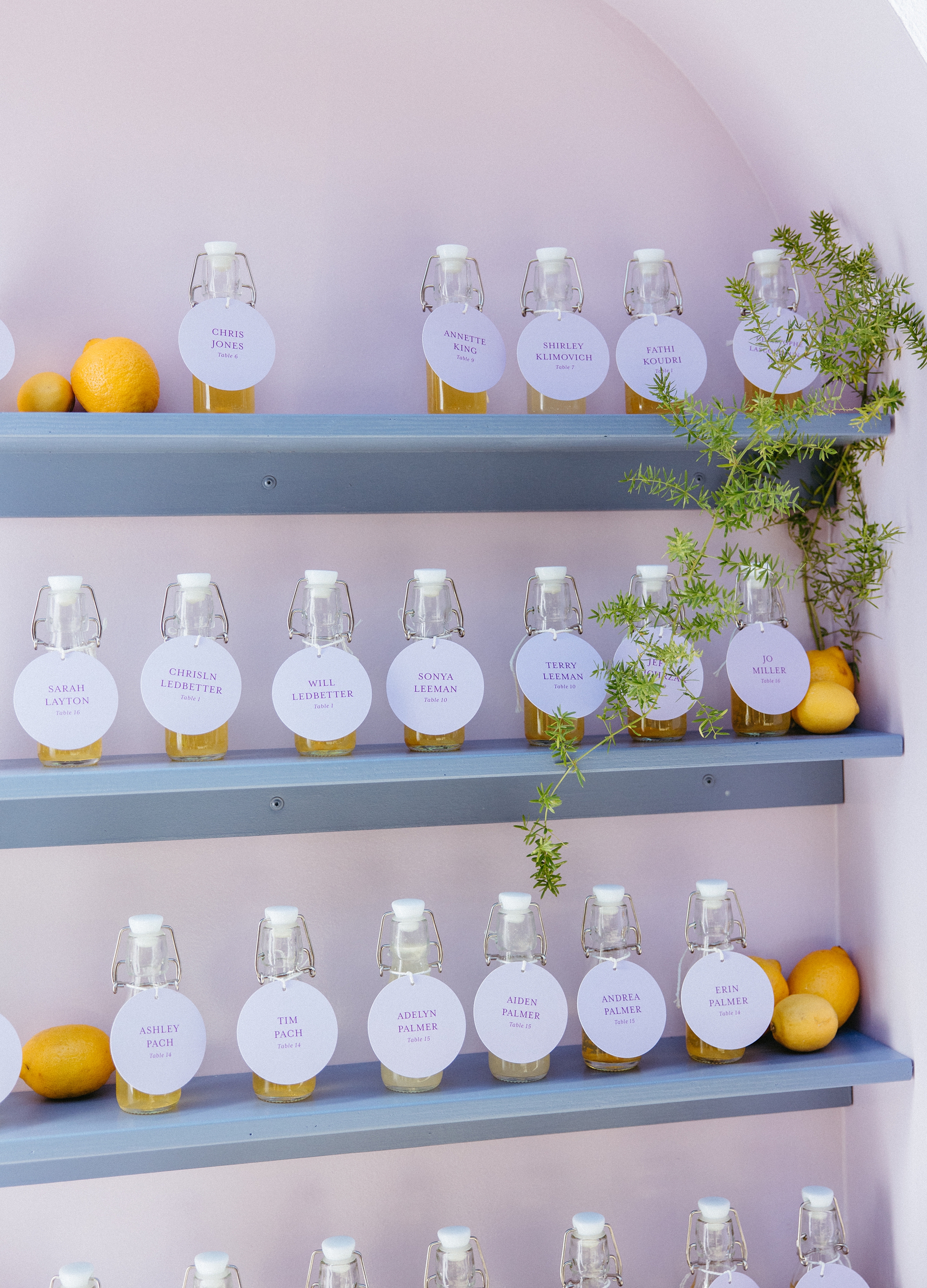 escort tags hang from bottles of limoncello for interactive seating chart 