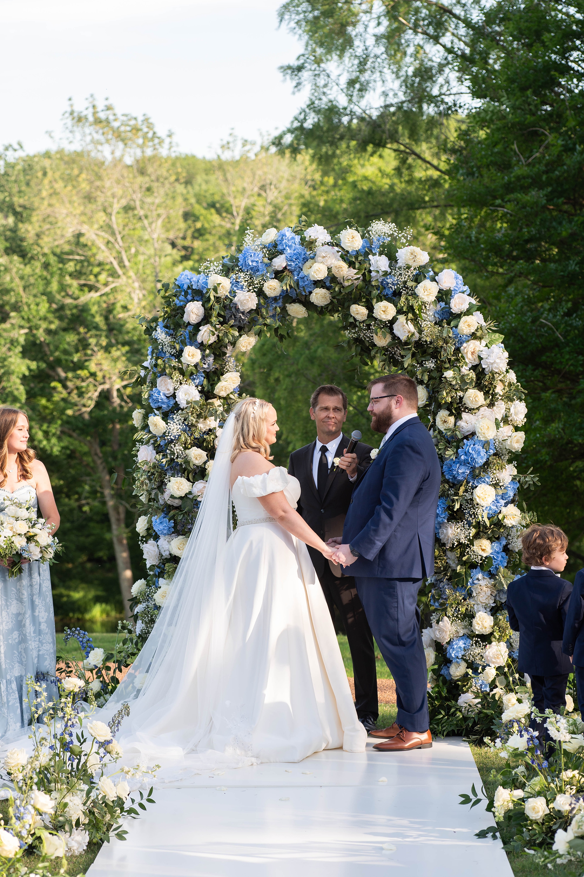 Bride and groom under white and blue floral arch at Elegant Spring Wedding in Nashville at Cheekwood Estate 