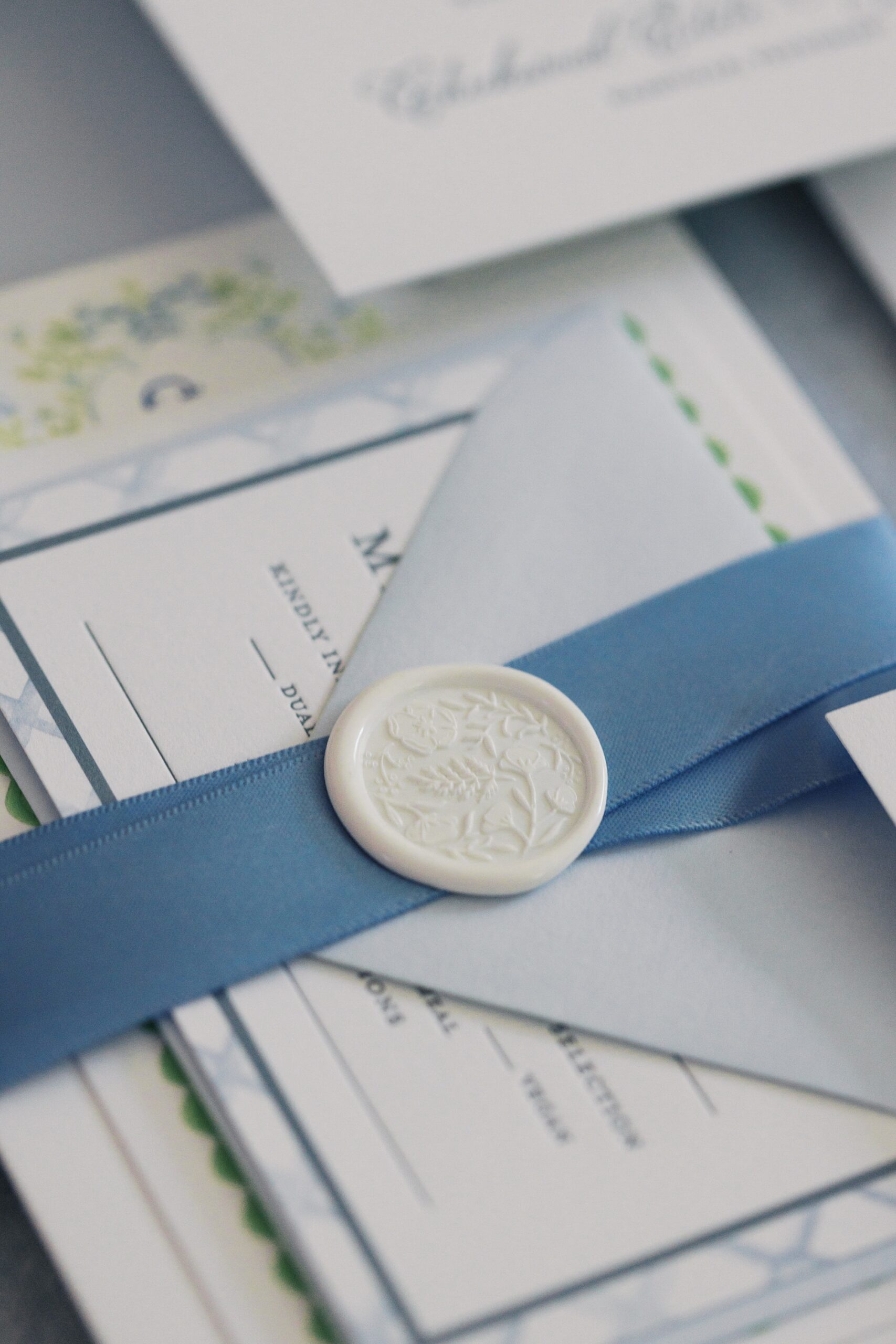 invitation stack with blue wrap complete with a white wax seal
