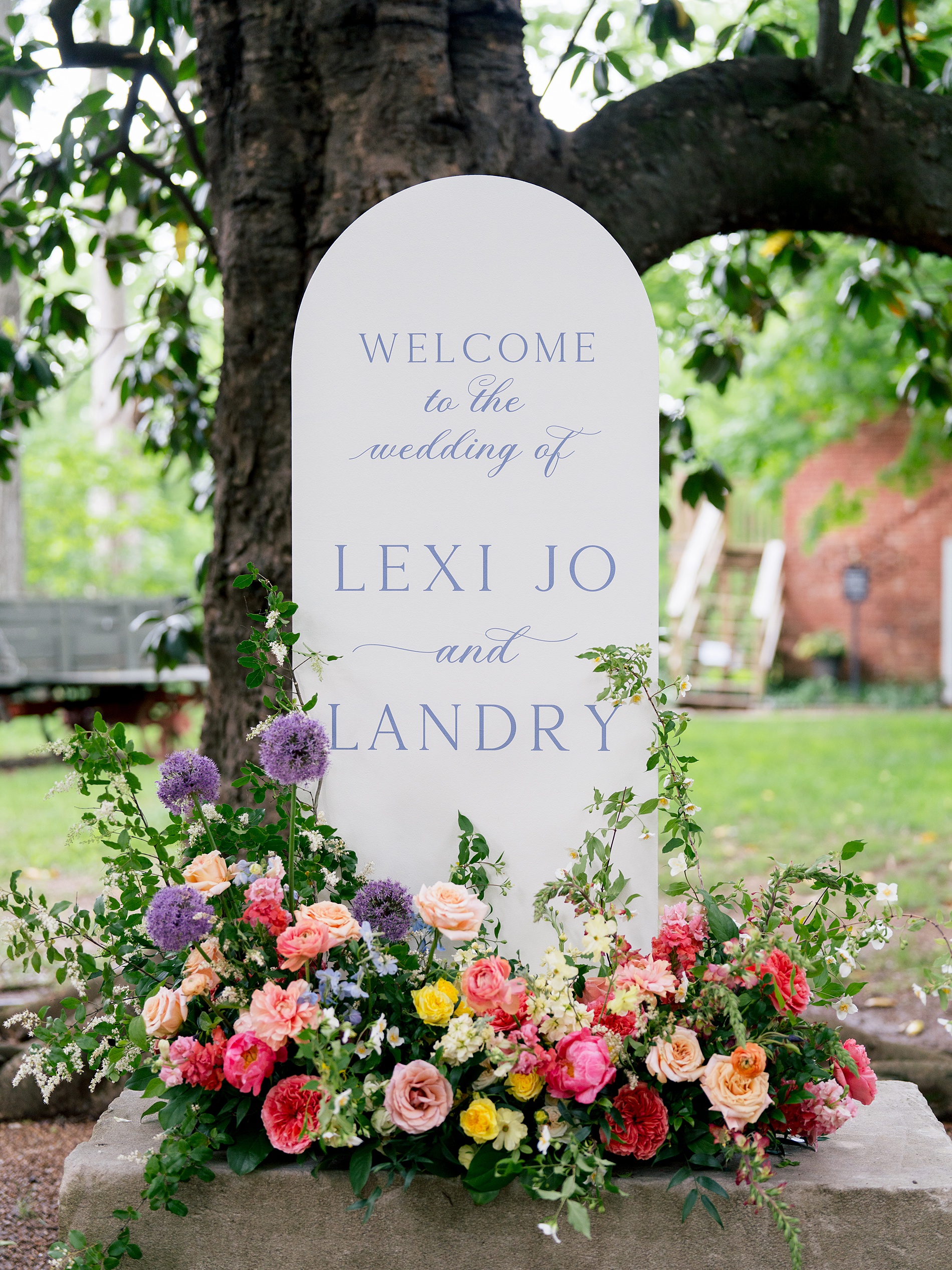 Wedding welcome sign surrounded by vibrant spring flowers