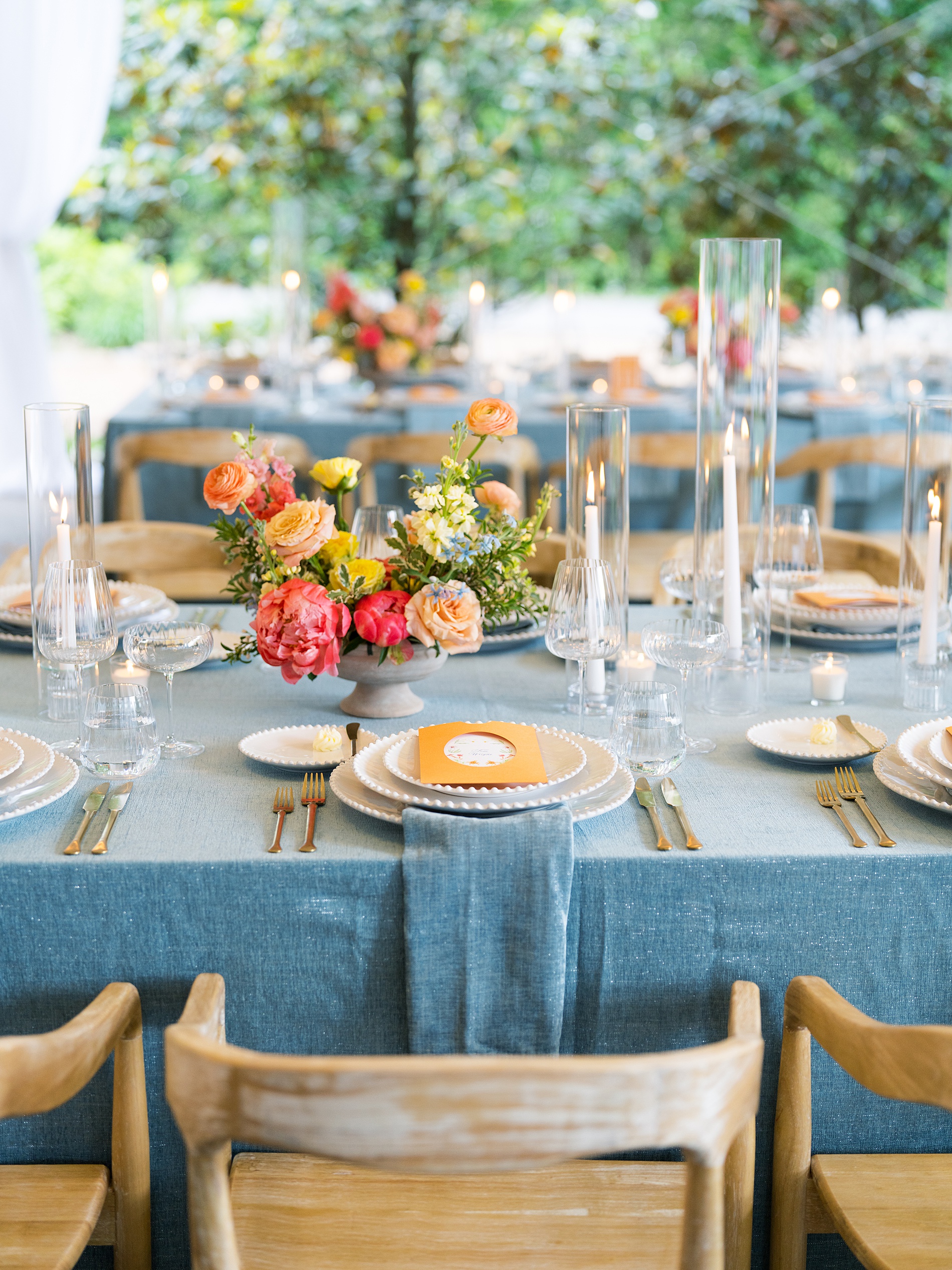 orange wedding menus pop against blue tablecloths at wedding reception in Nashville