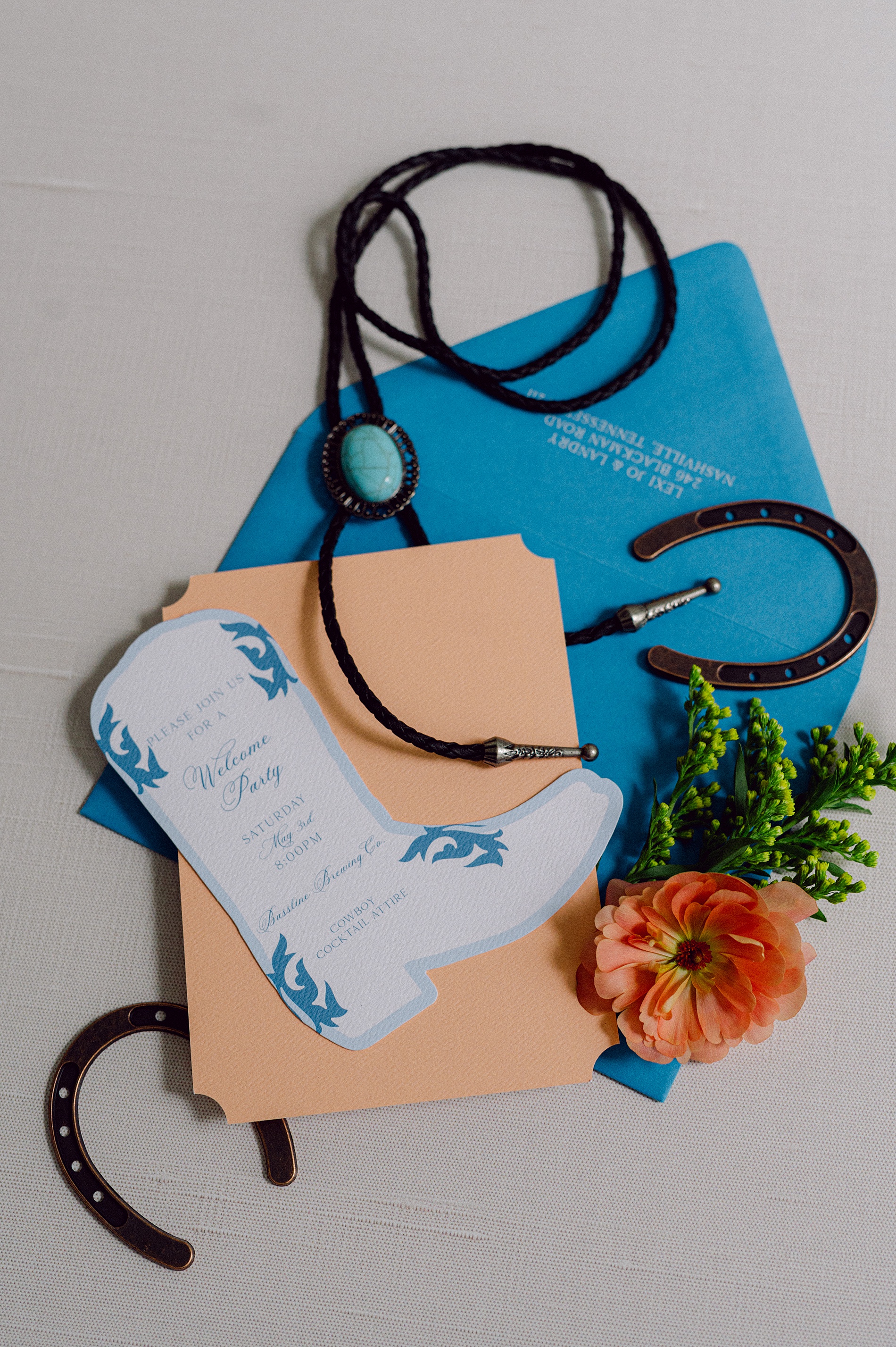 bold blue envelope with cowboy shaped welcome party details card 