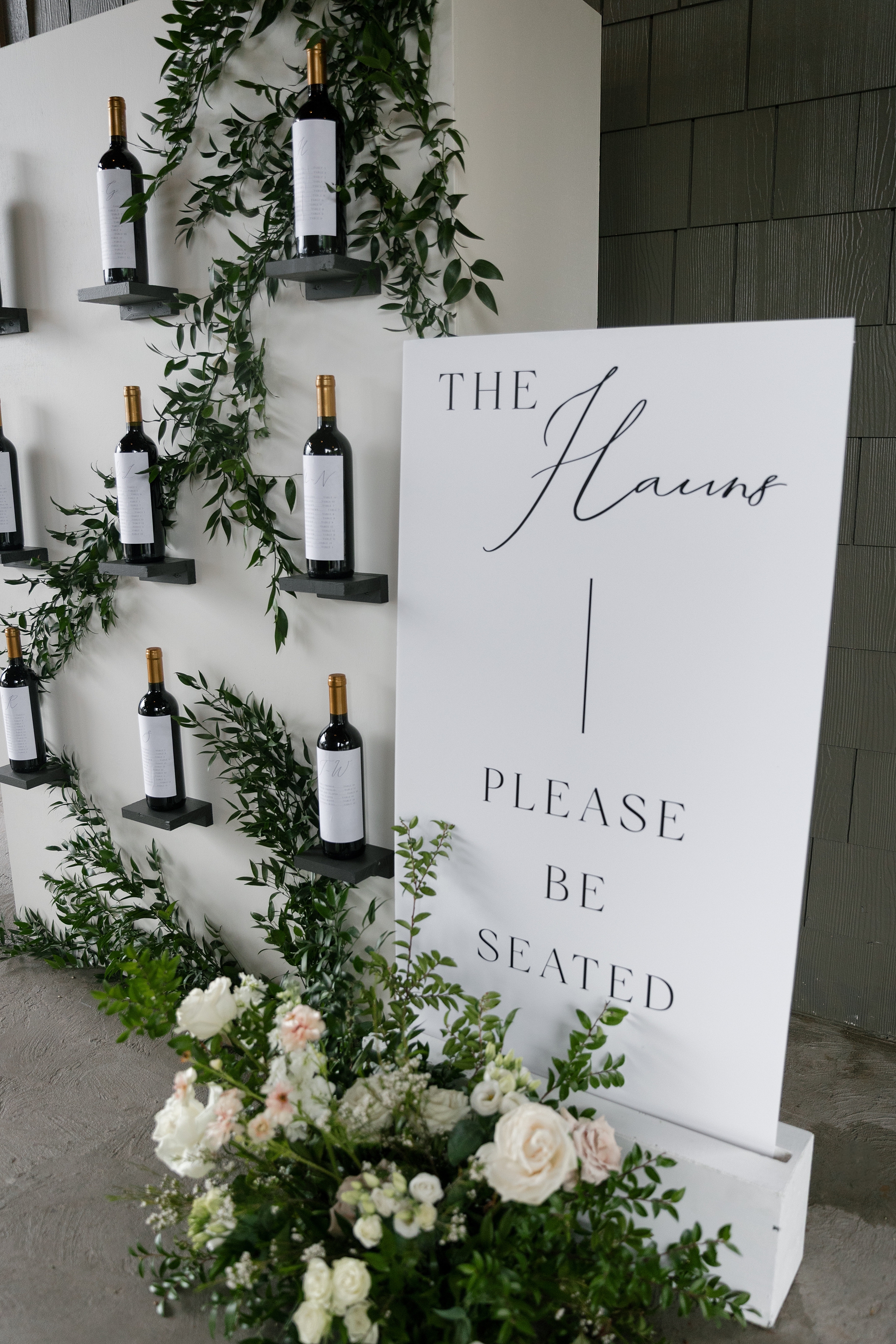 custom wine labels on wine bottles featuring table assignments for wedding seating chart 