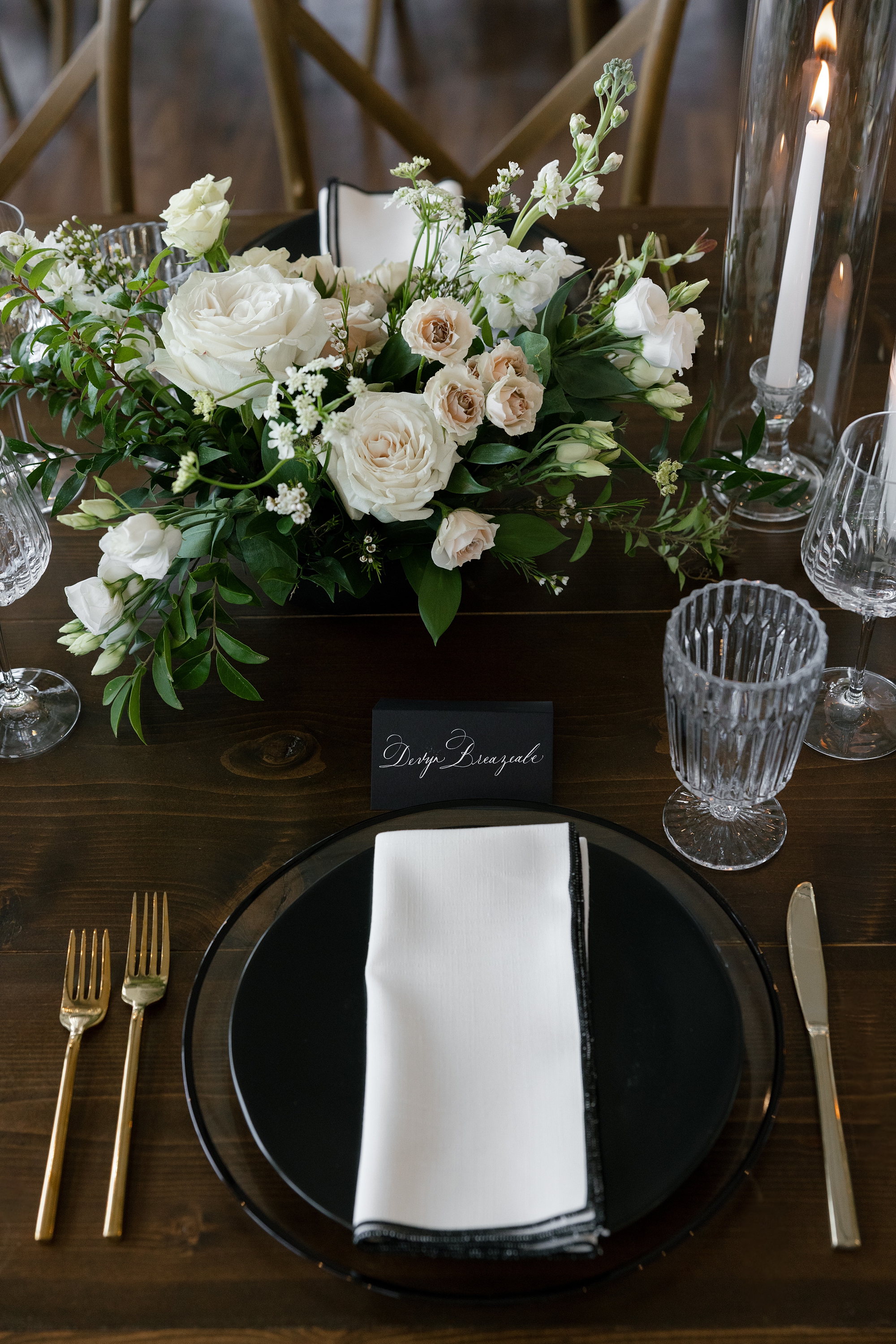 elegant tablecape featuring black place card with white calligraphy and black plate and crisp white napkin