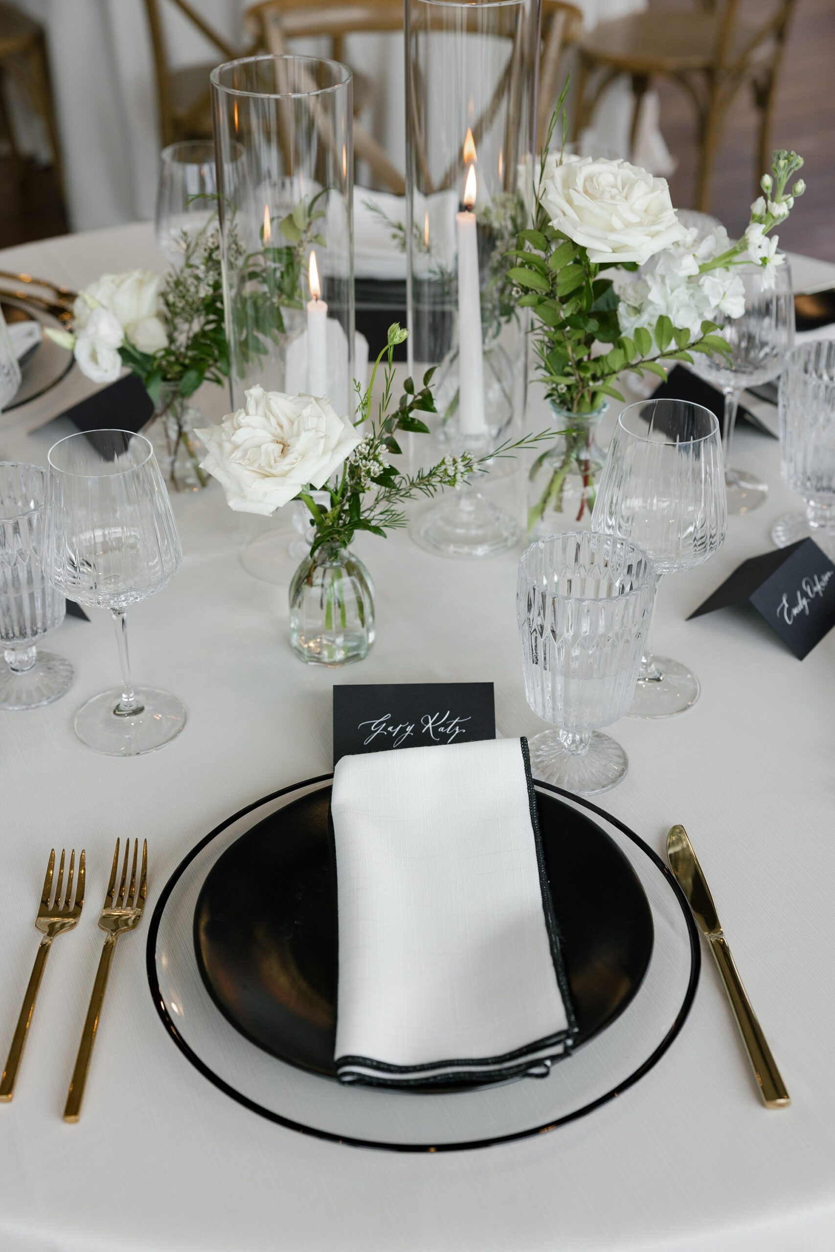 place setting with black and white details and black place card with white calligraphy designed by Full-service wedding design house 