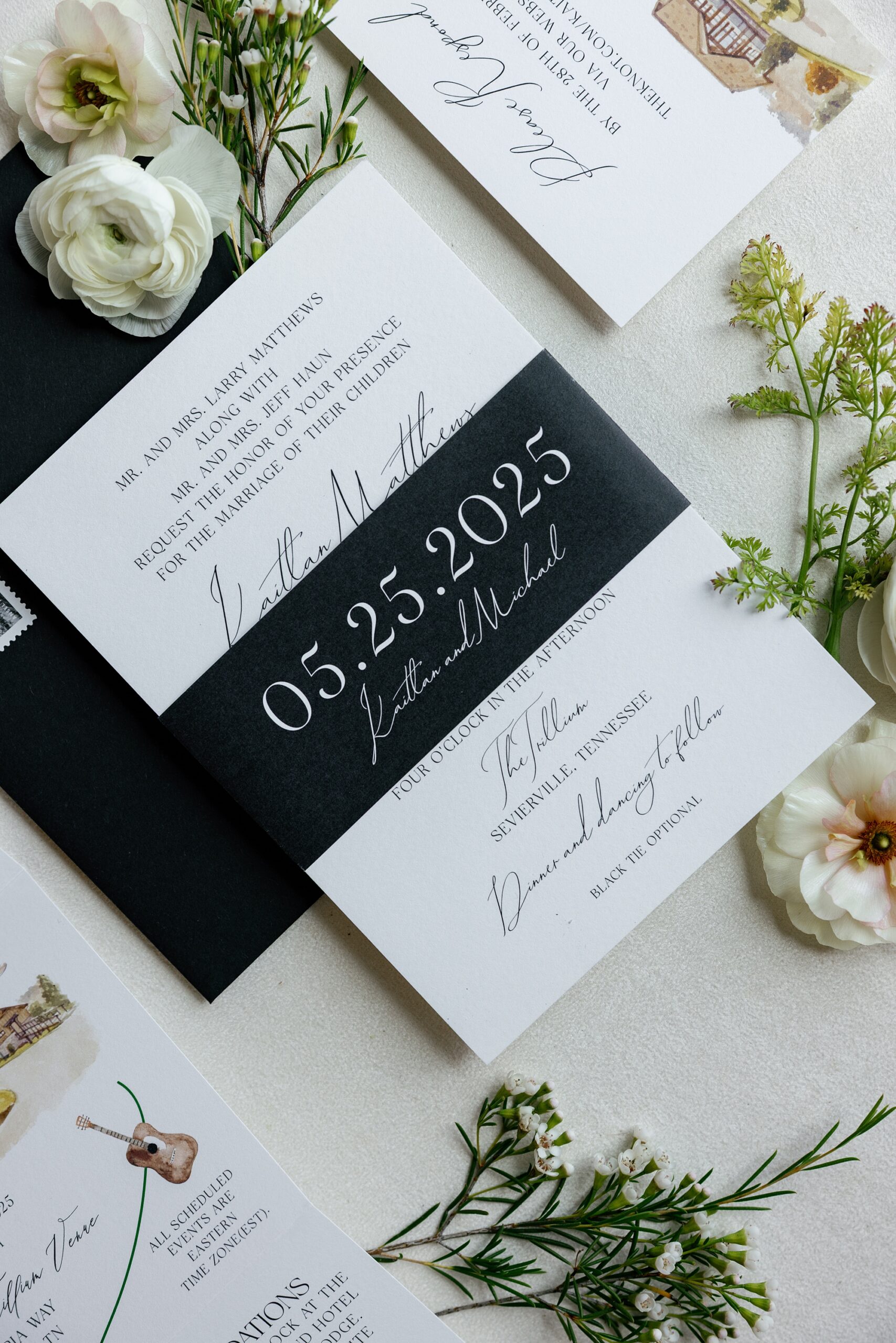 sleek black band holds invitation suite together and features wedding date and couples name 