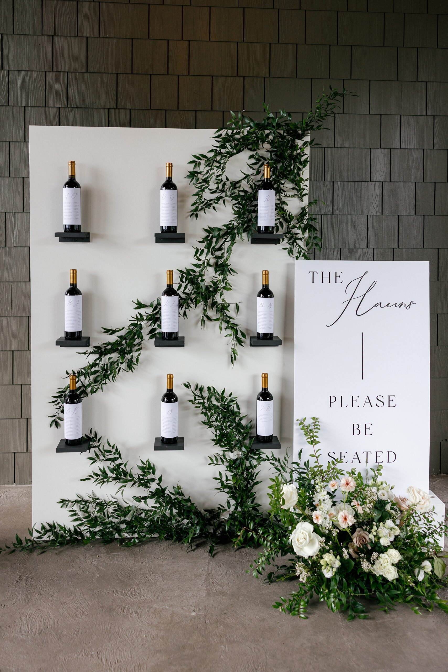Timeless black and white wedding with custom wine bottle seating chart and title sign created by full-service wedding design house