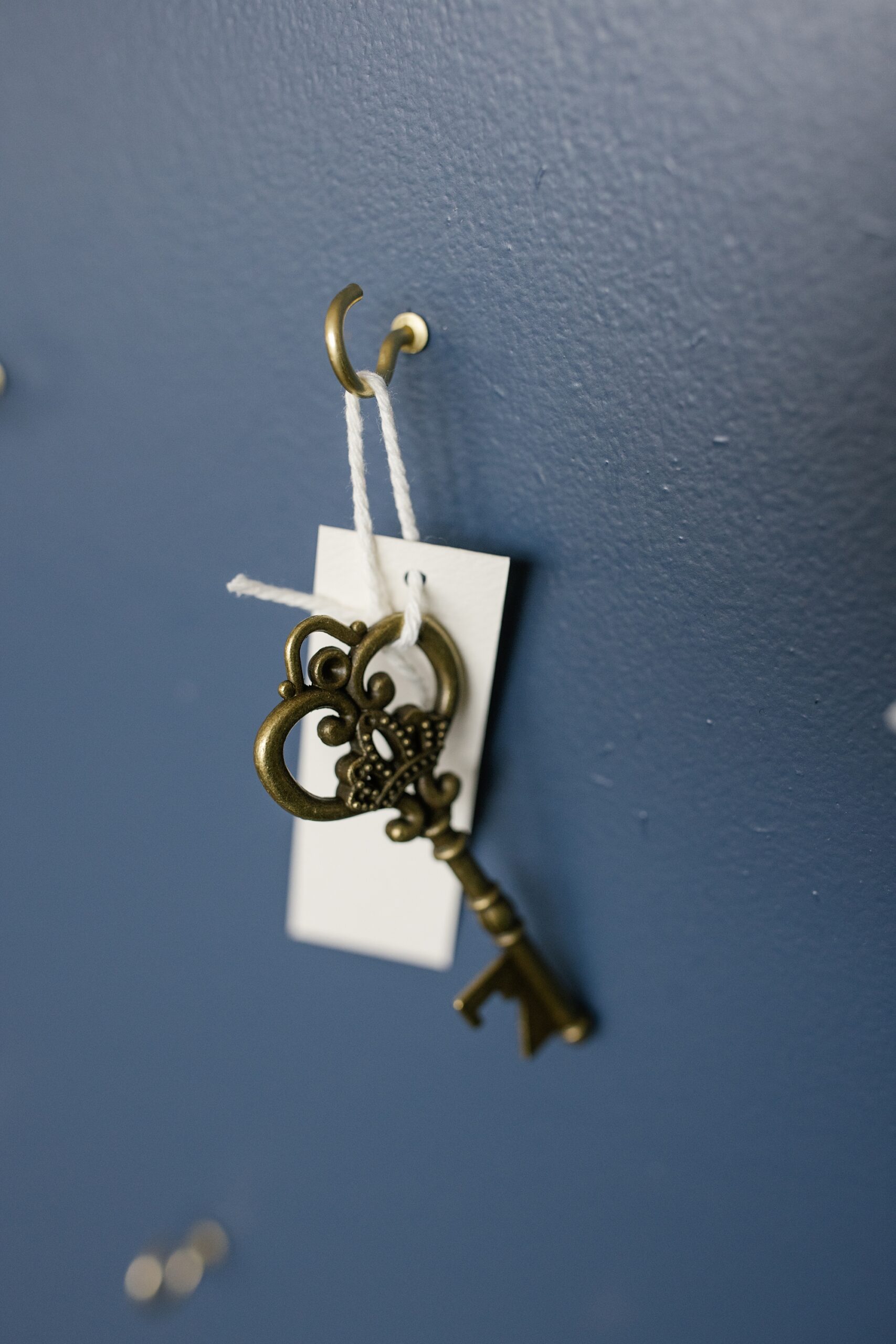 vintage hotel keys hanging on gold hooks for custom seating chart display 