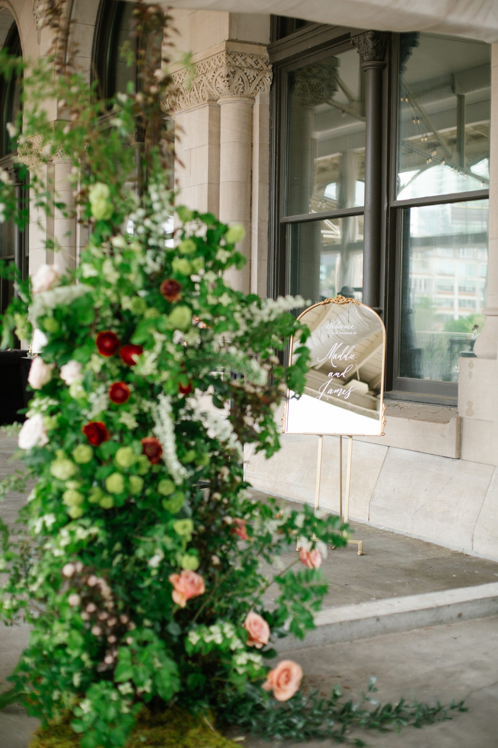 mirrored wedding welcome sign with floral display 